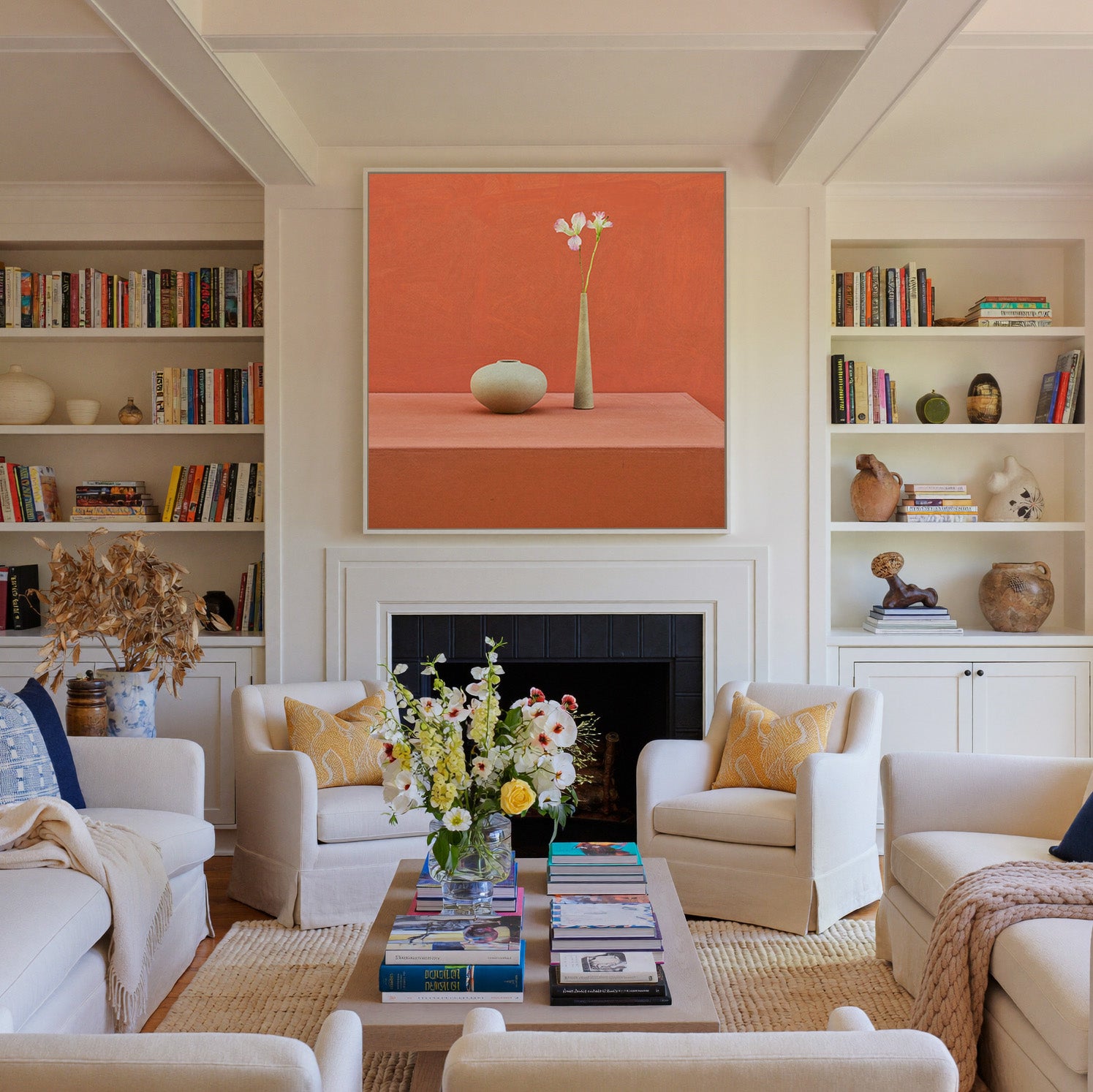 terracotta still life with vase and single stem canvas wall art in a white frame above a fireplace