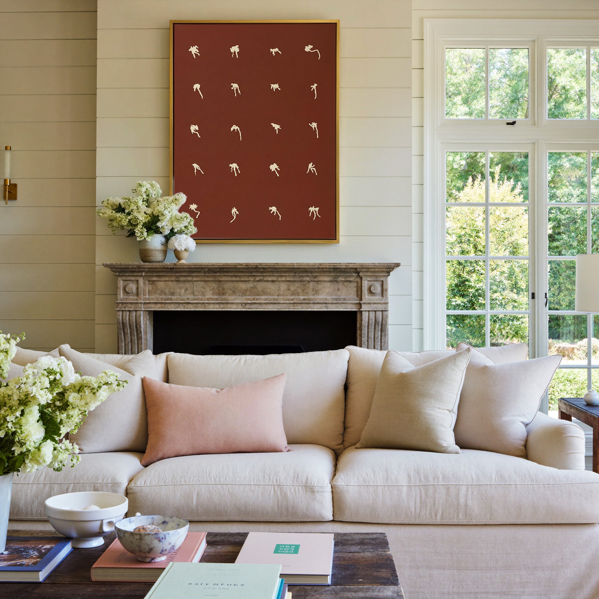 cream floral forms on a deep cocoa ground canvas wall art in a gold frame above a mantel
