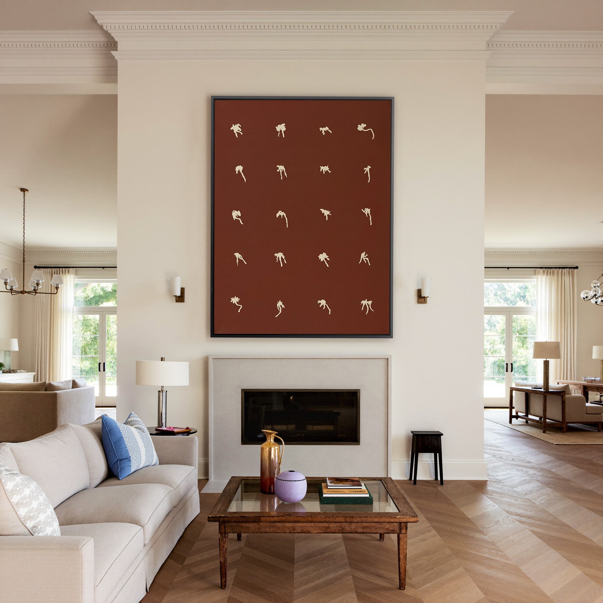 cream floral forms on a deep cocoa ground canvas wall art in a black frame above a mantel