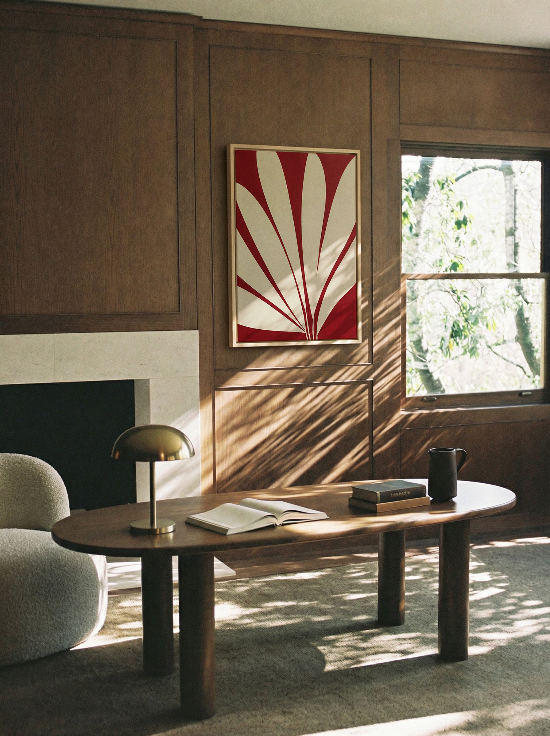 deep red and cream abstract with radiating canvas wall art in a natural wood frame in a styled room setting