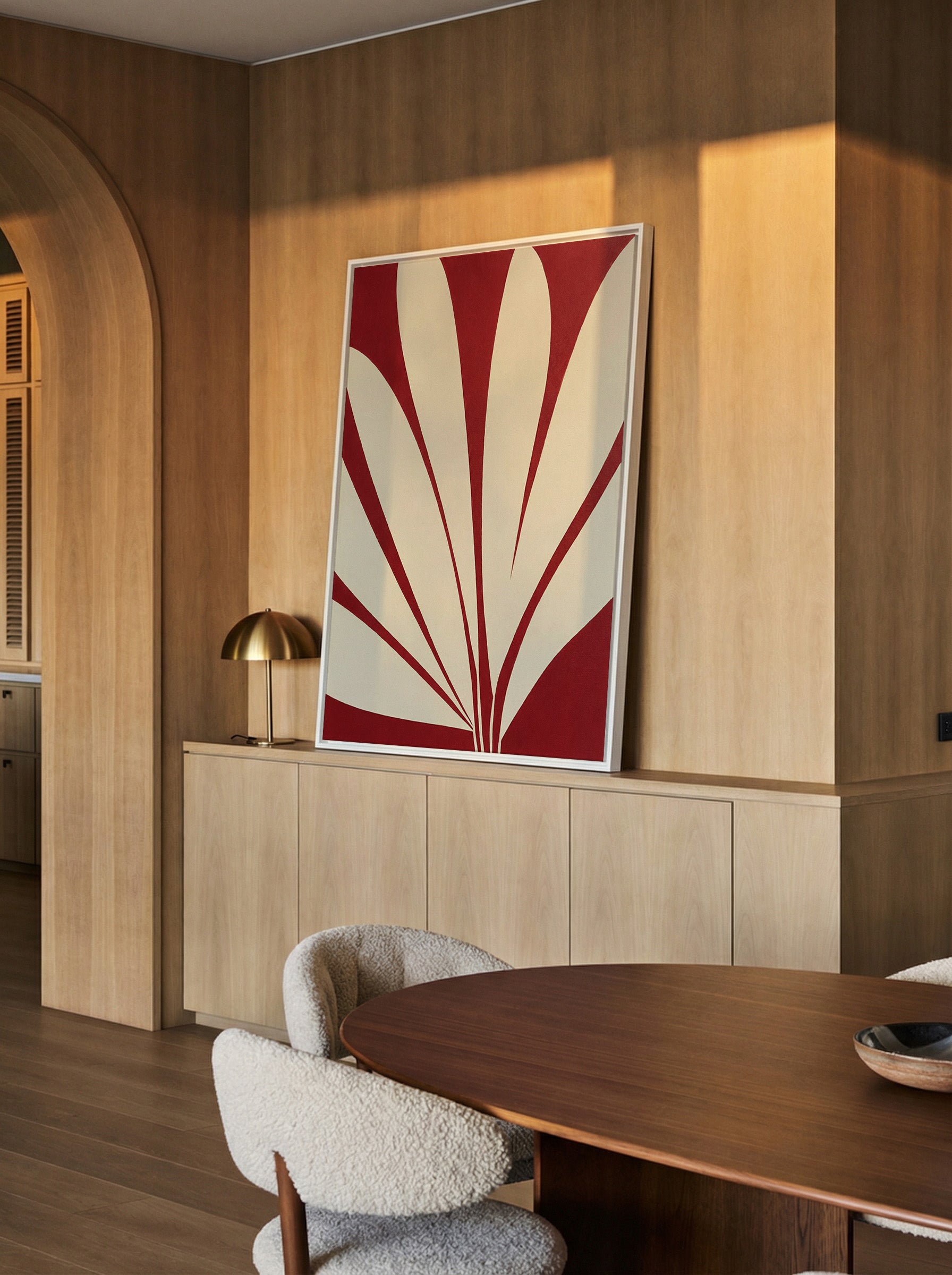 deep red and cream abstract with radiating canvas wall art in a white frame in a styled room setting