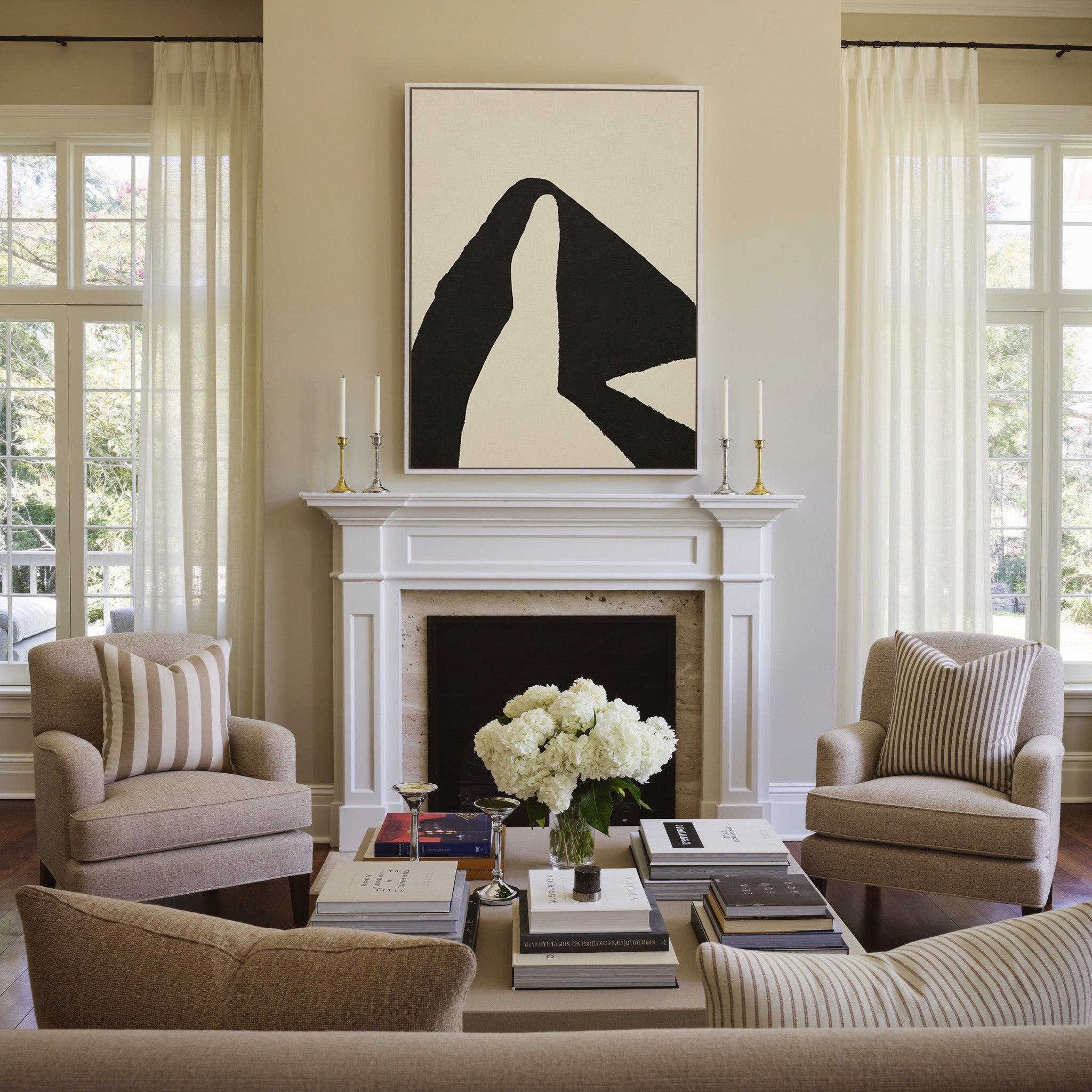 black and cream abstract with sweeping angular canvas wall art in a white frame above a mantel