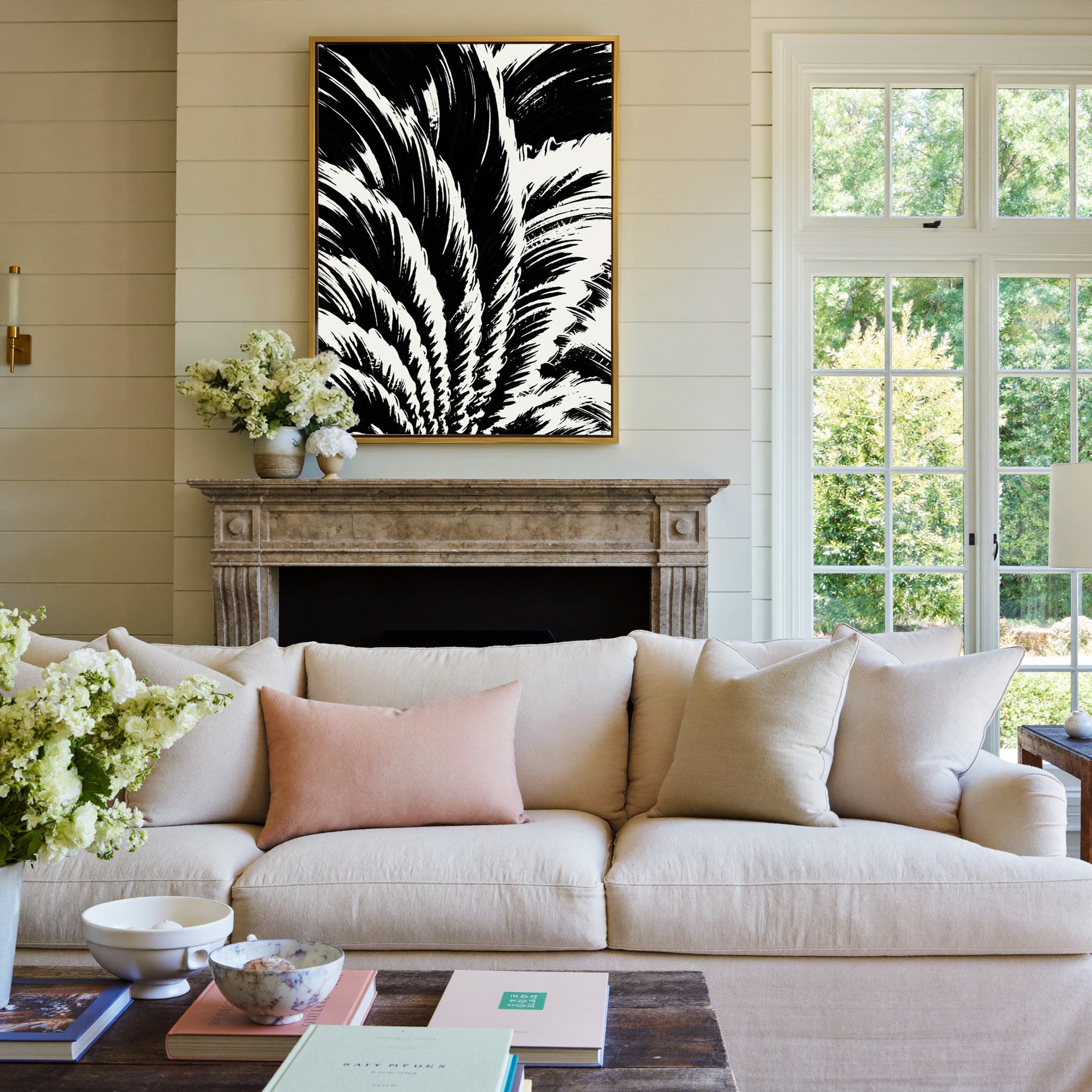 black and white palm leaf abstract canvas wall art in a gold frame above a mantel