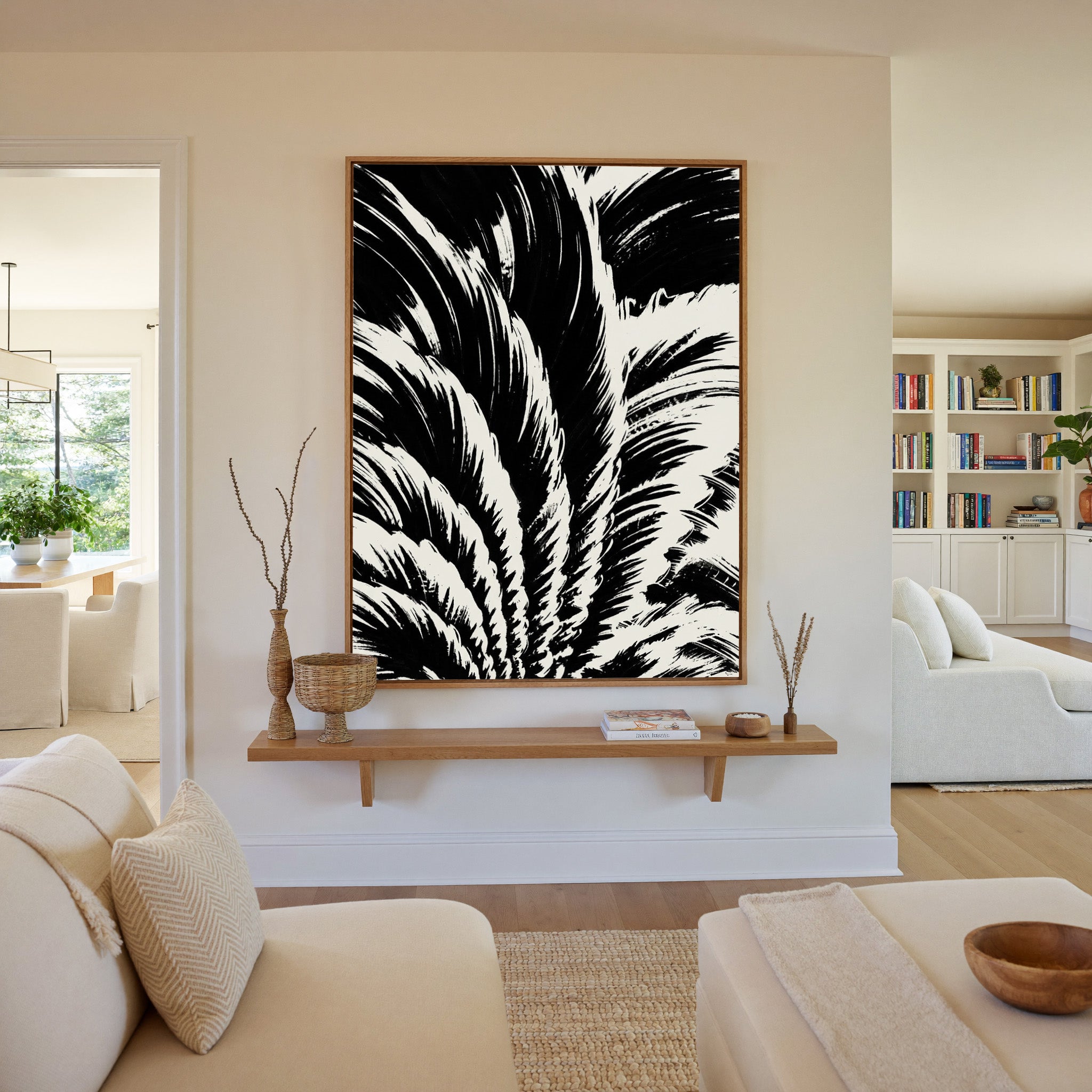 black and white palm leaf abstract canvas wall art in an oak frame in a living room