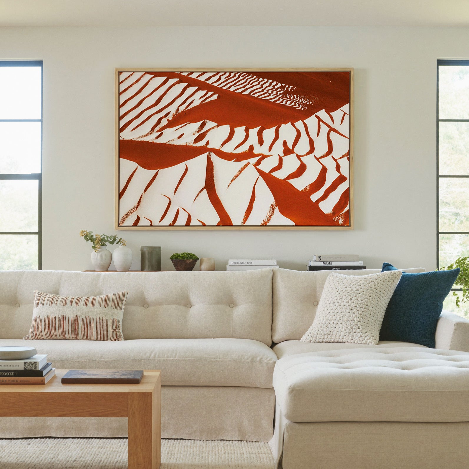 rust and cream abstract with sweeping diagonal canvas wall art in a natural wood frame in a living room