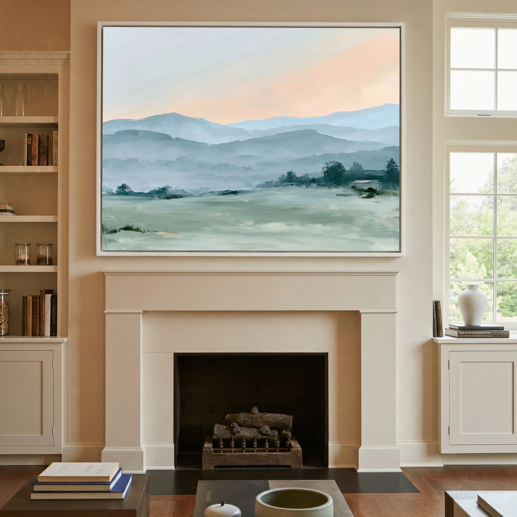 misty blue hills with a peach sky canvas wall art in a white frame above a mantel