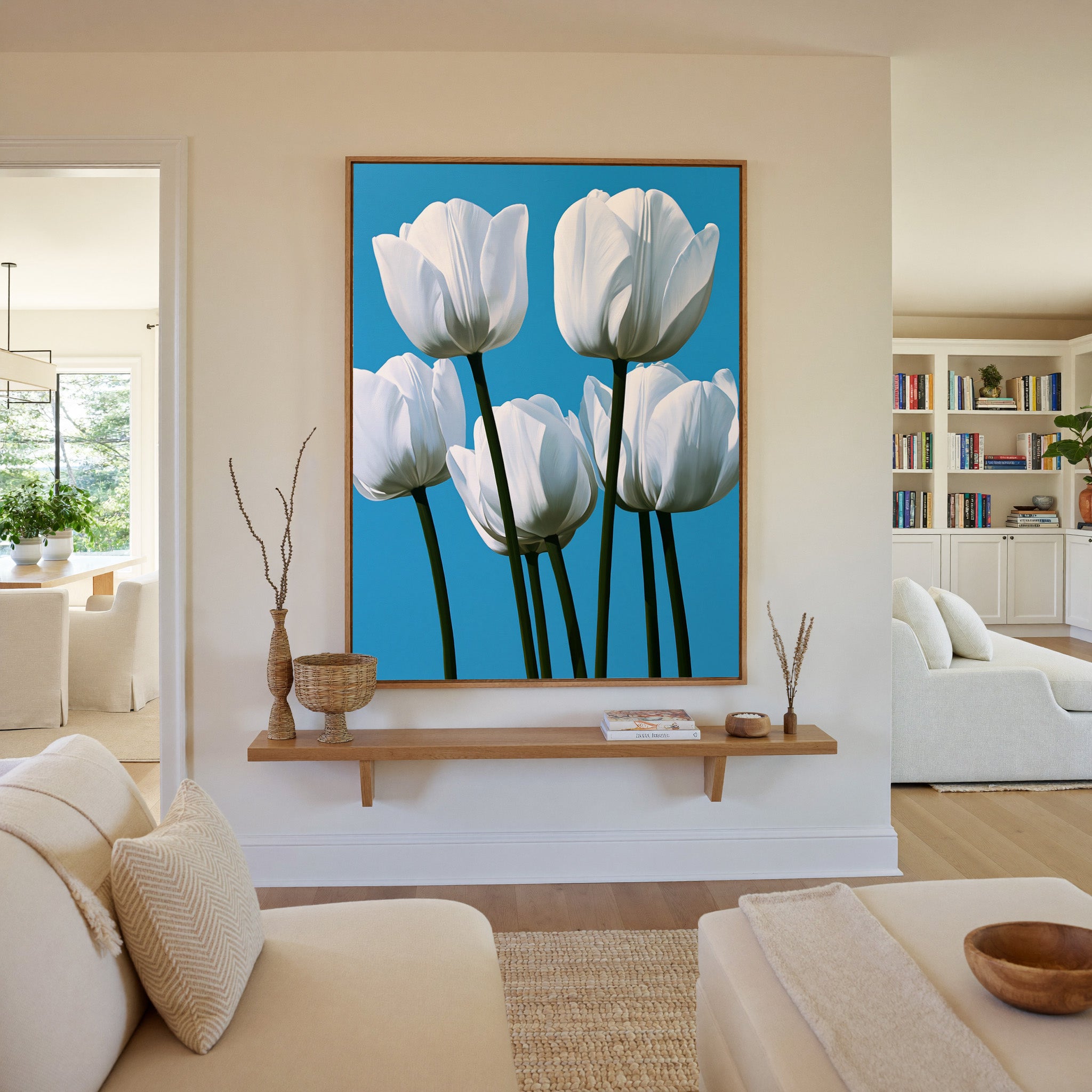 white tulips with deep green stems on a bright canvas wall art in an oak frame in a living room