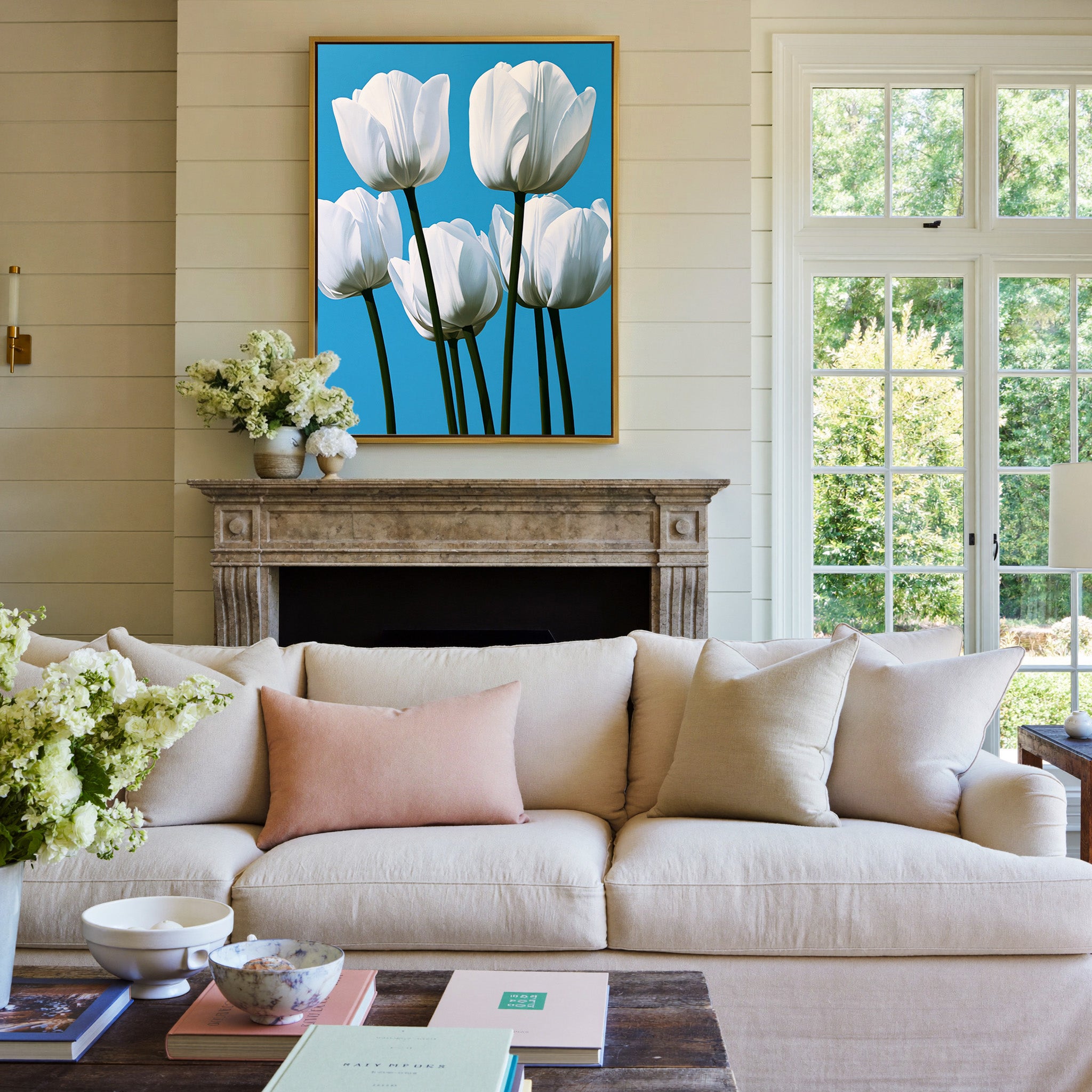 white tulips with deep green stems on a bright canvas wall art in a gold frame above a mantel
