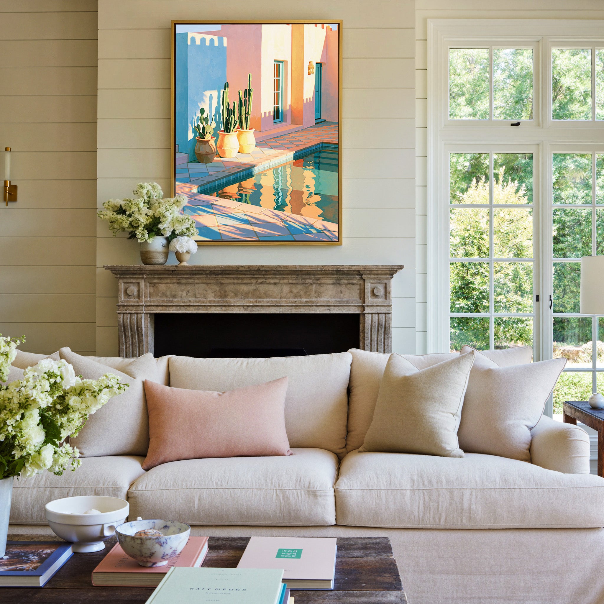 pastel courtyard with cactus pots and pool canvas wall art in a gold frame above a mantel