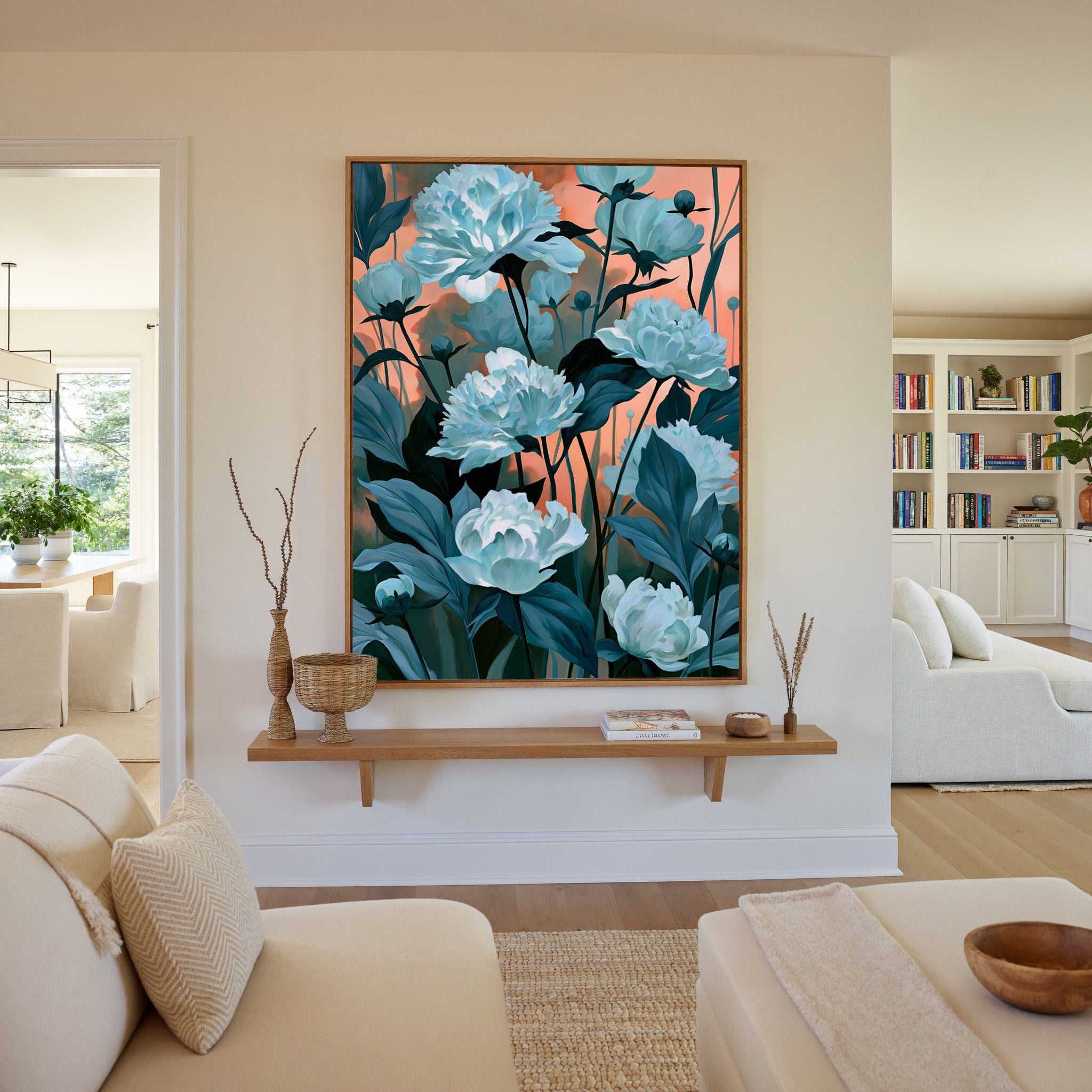 white flowers with teal leaves on a coral dusk canvas wall art in an oak frame in a living room