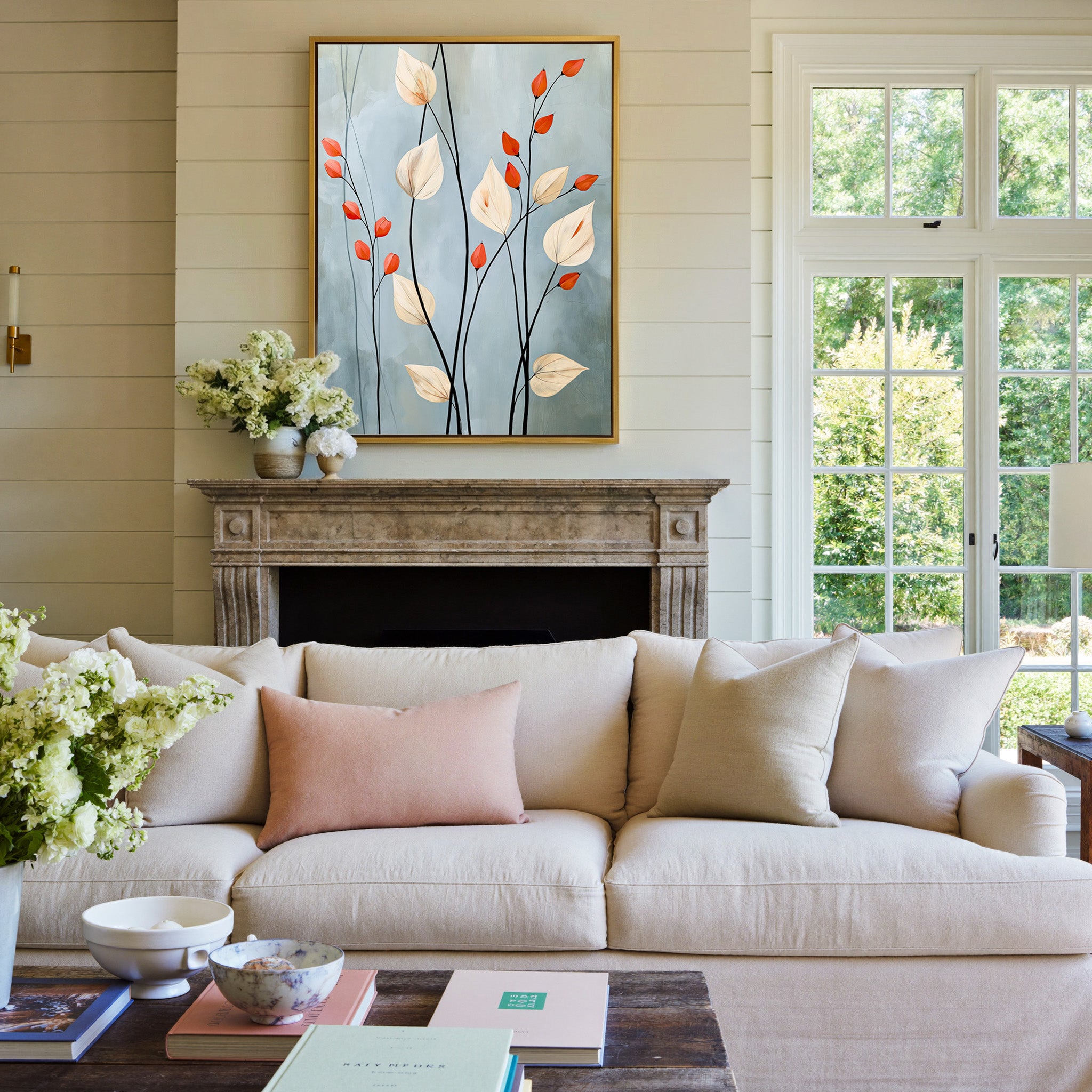 cream leaves and black stems on a blue gray canvas wall art in a gold frame above a mantel