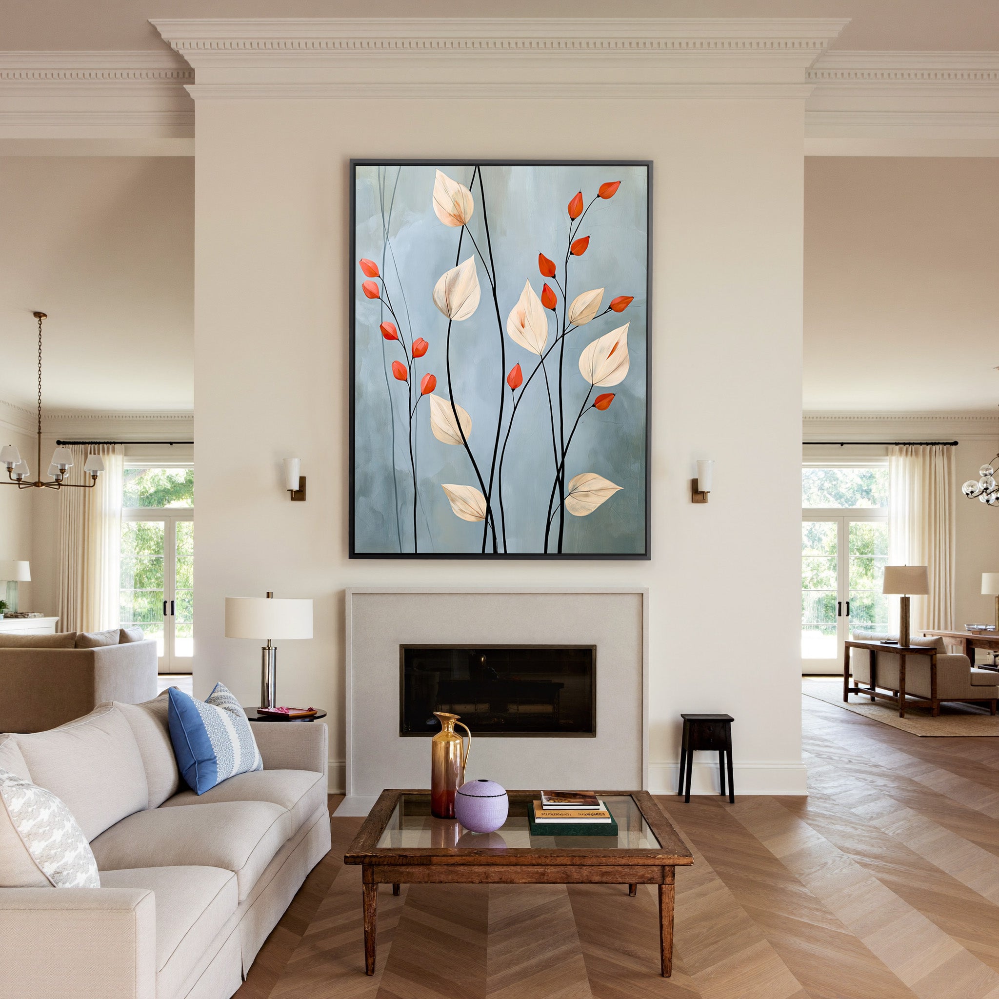 cream leaves and black stems on a blue gray canvas wall art in a black frame above a mantel