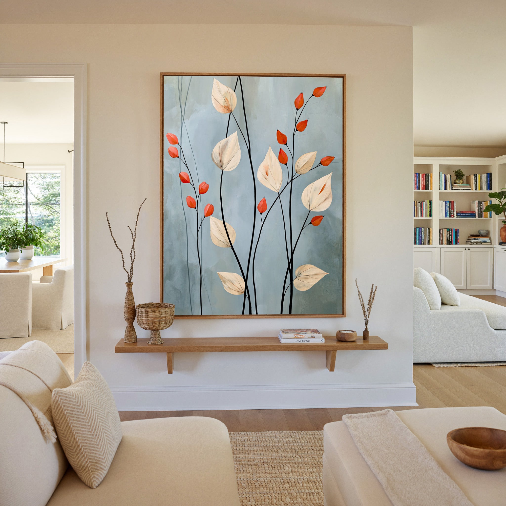 cream leaves and black stems on a blue gray canvas wall art in an oak frame in a living room