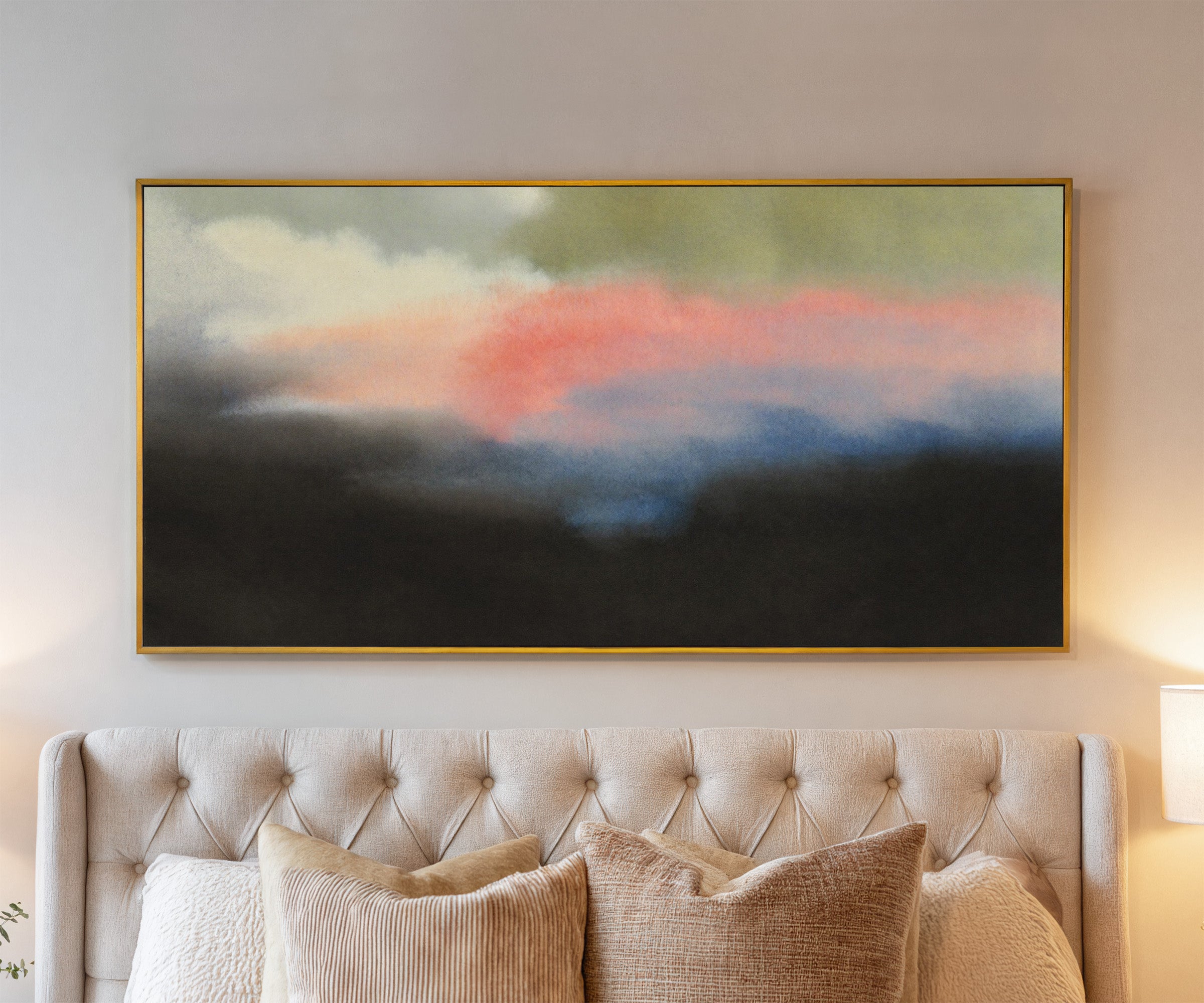 soft pink and blue abstract with dark grounding canvas wall art in a gold frame above a bed