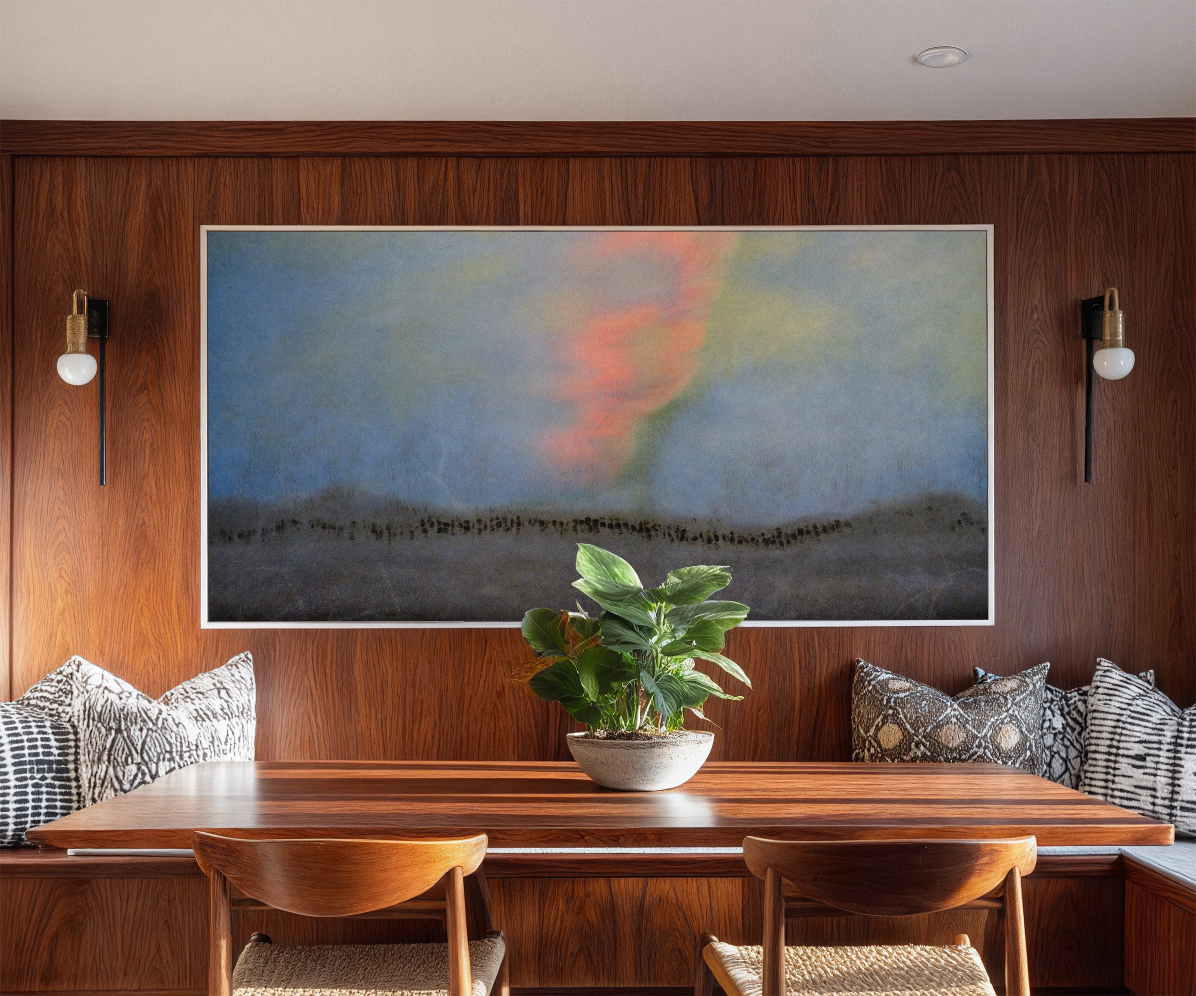 soft blue abstract with coral glow and dark canvas wall art in a white frame in a styled room setting