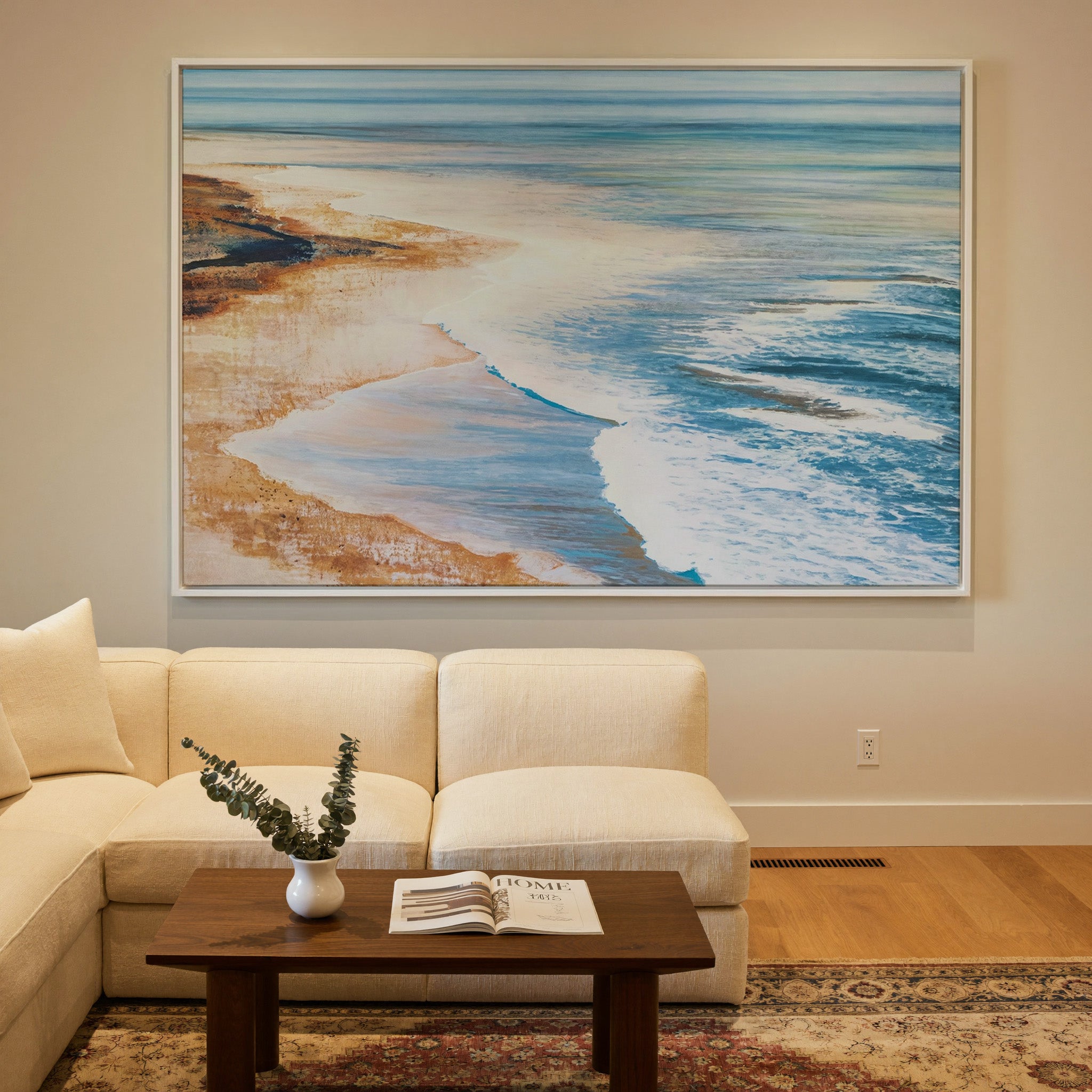 blue water meeting warm sand canvas wall art in a white frame in a styled room setting