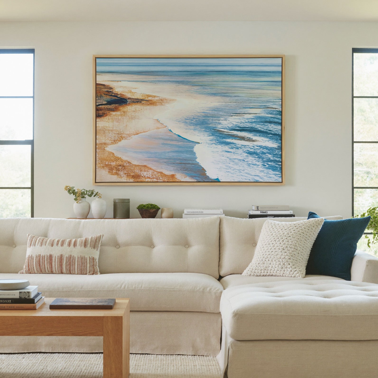 blue water meeting warm sand canvas wall art in a natural wood frame in a living room