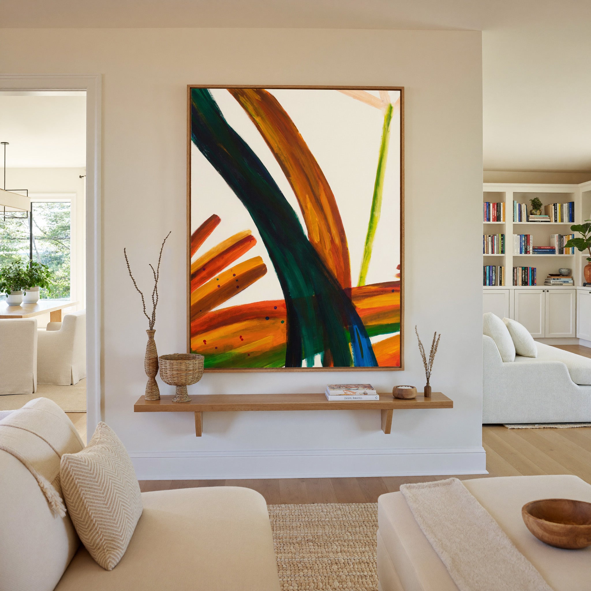 bold orange, green, and blue abstract with canvas wall art in an oak frame in a living room