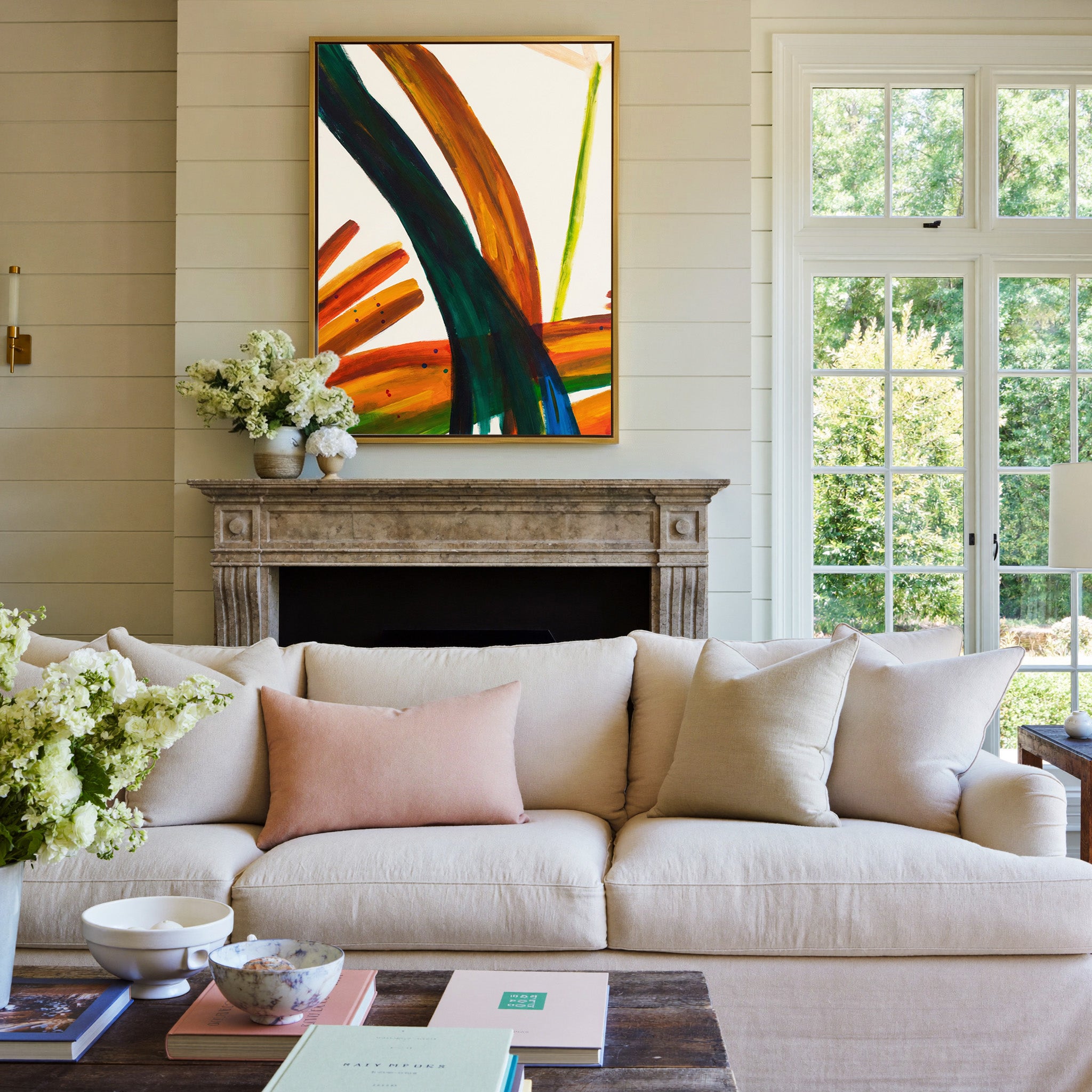 bold orange, green, and blue abstract with canvas wall art in a gold frame above a mantel