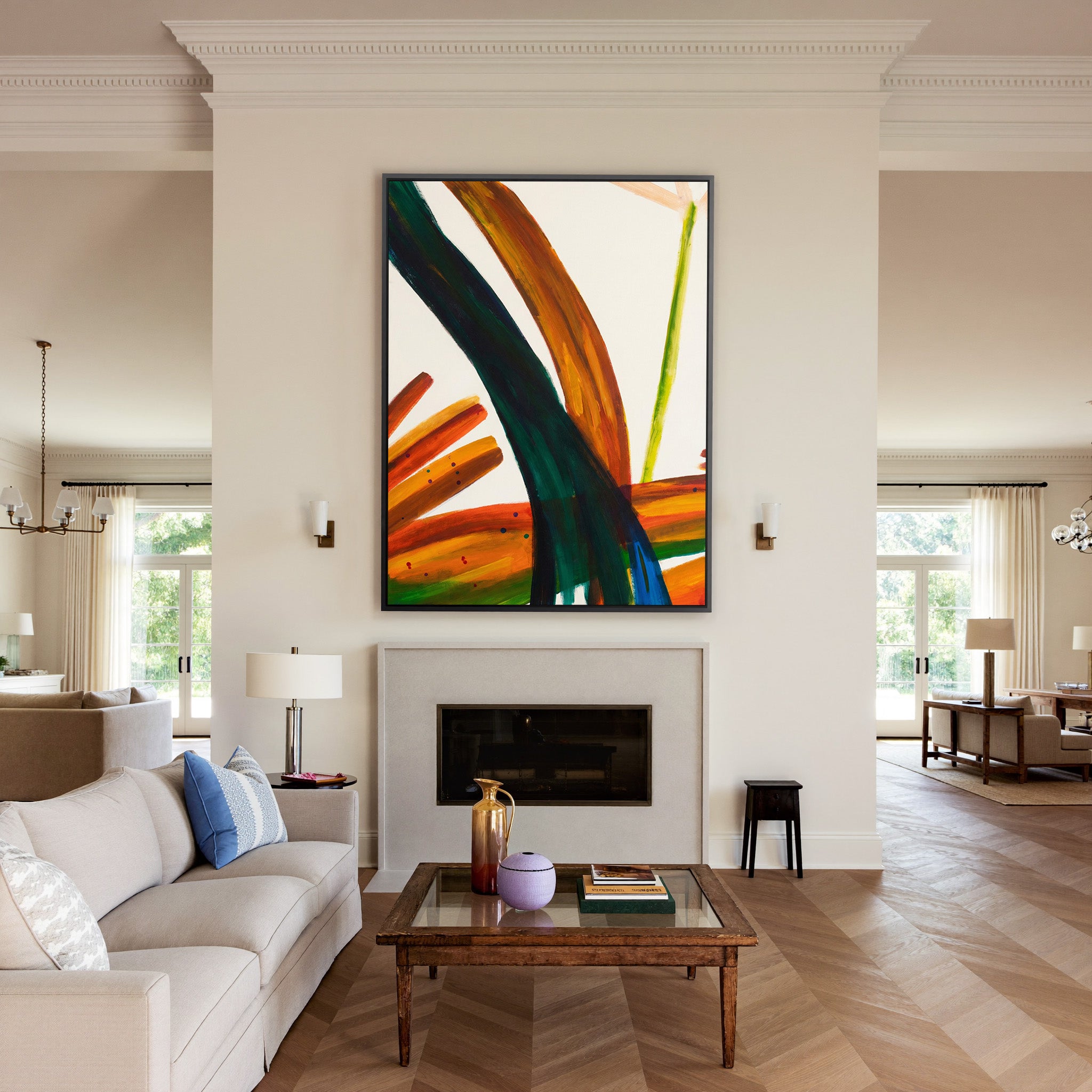 bold orange, green, and blue abstract with canvas wall art in a black frame above a mantel