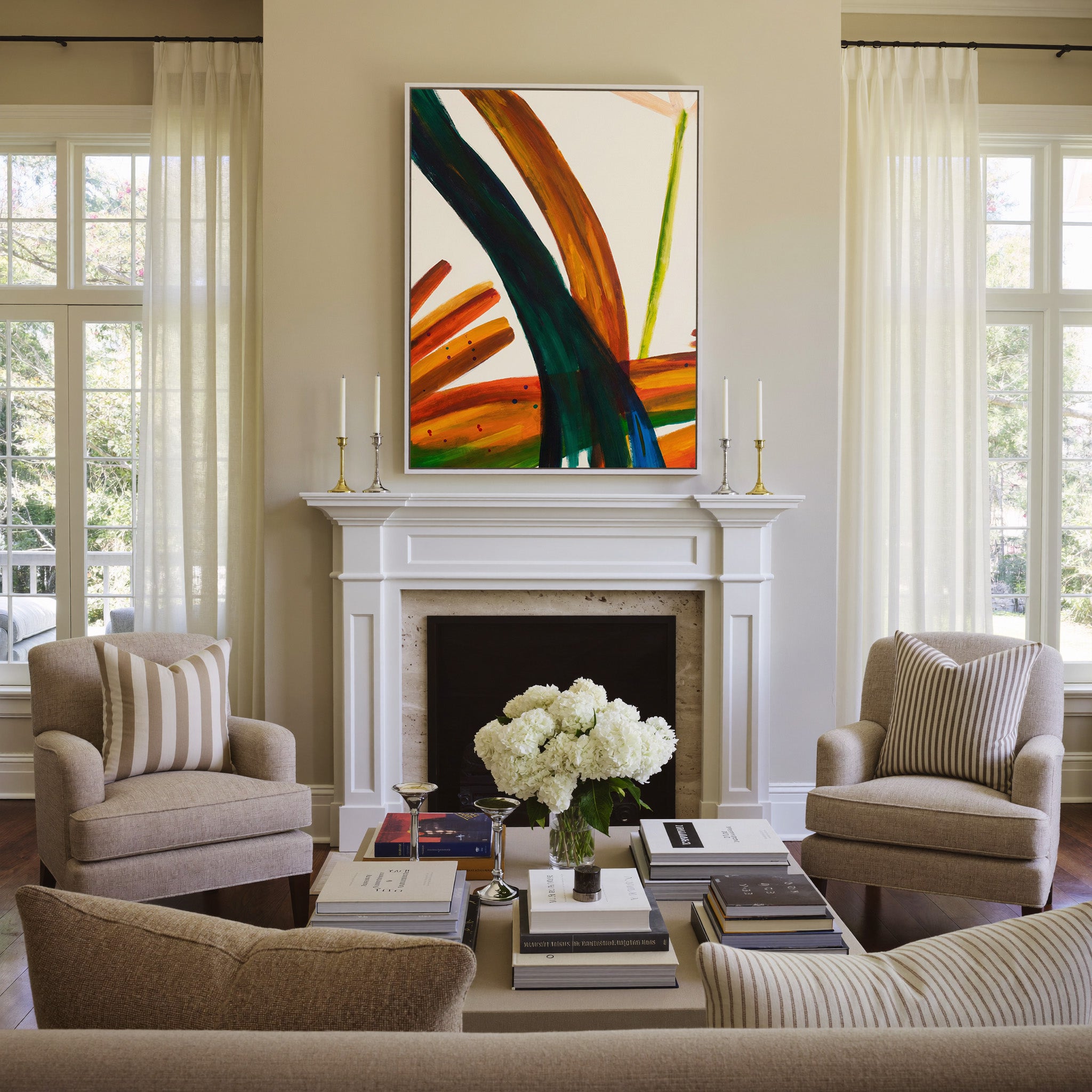 bold orange, green, and blue abstract with canvas wall art in a white frame above a mantel