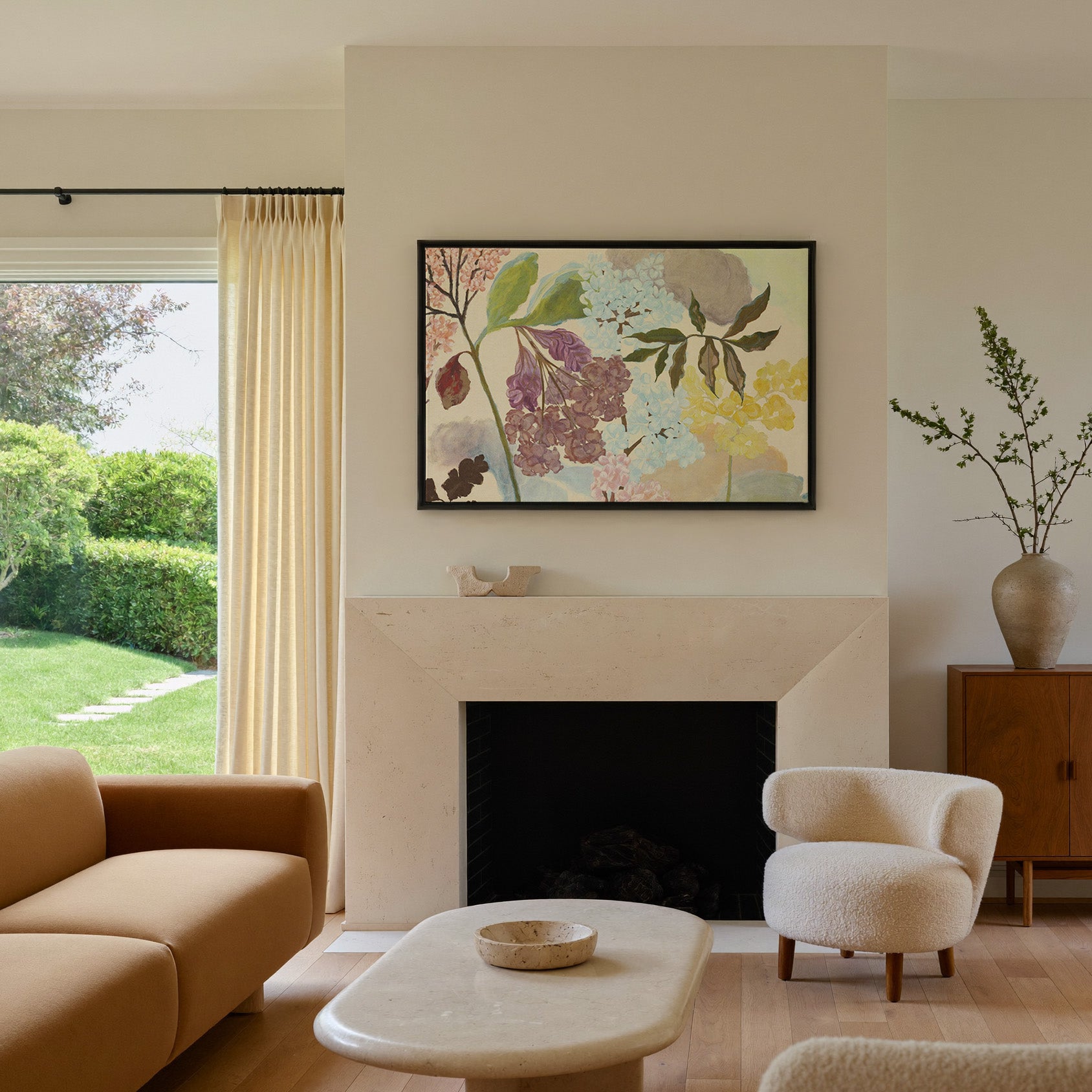 soft pastel floral branches with clustered canvas wall art in a black frame above a mantel