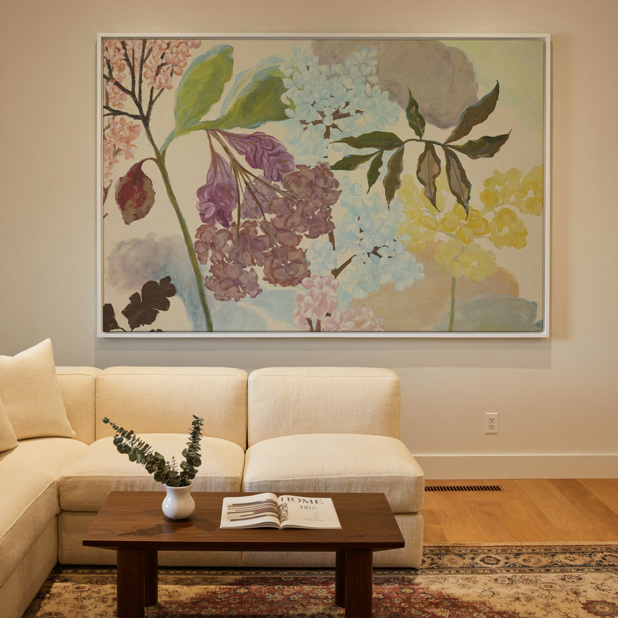 soft pastel floral branches with clustered canvas wall art in a white frame in a styled room setting