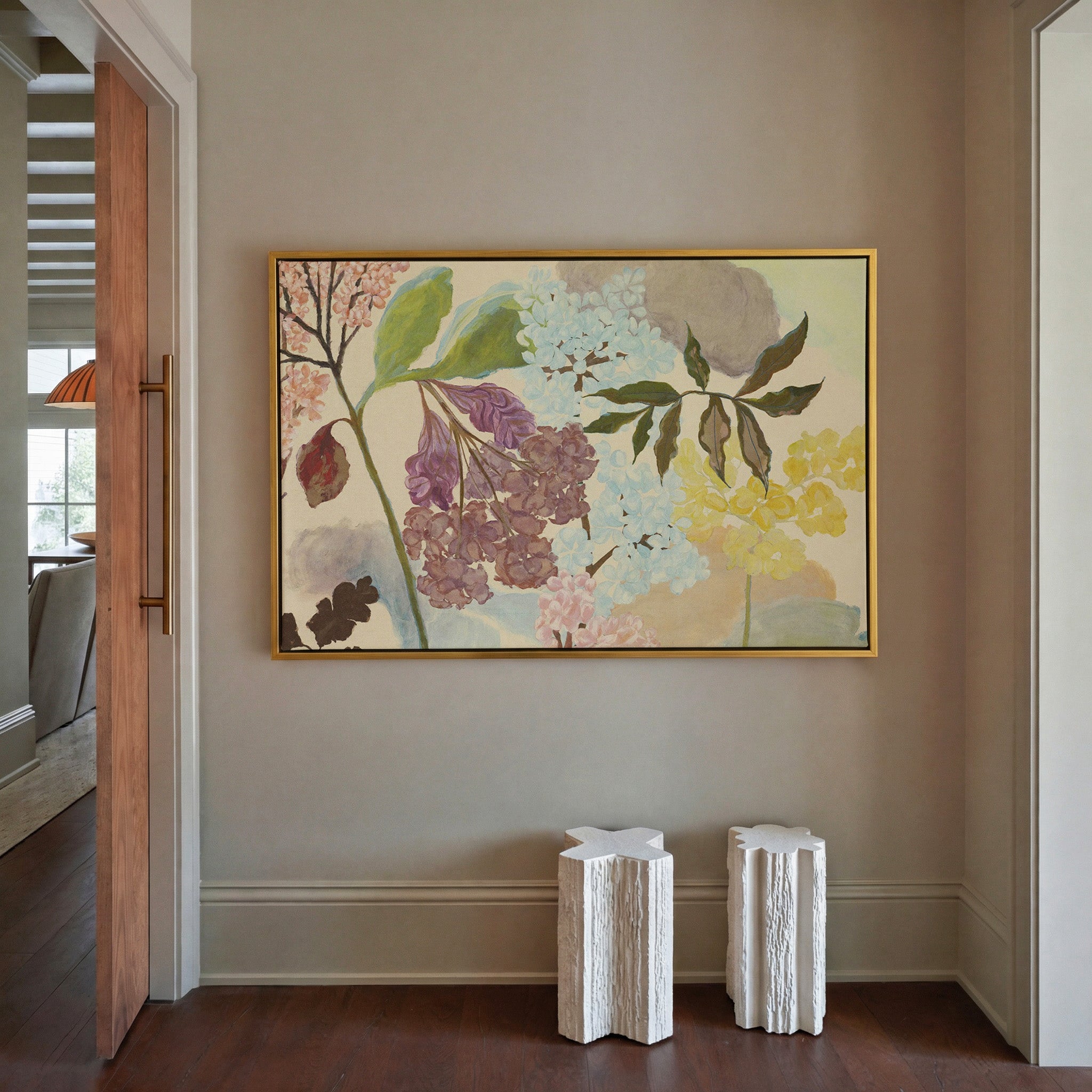 soft pastel floral branches with clustered canvas wall art in a gold frame in a styled room setting