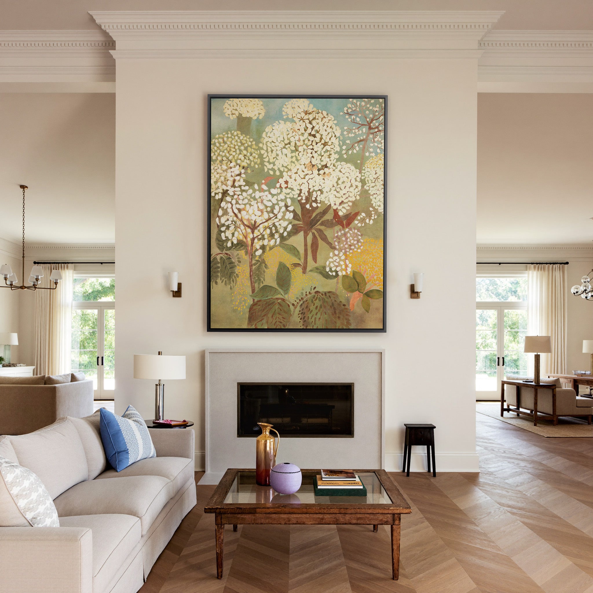 soft floral trees with cream blossoms and muted canvas wall art in a black frame above a mantel