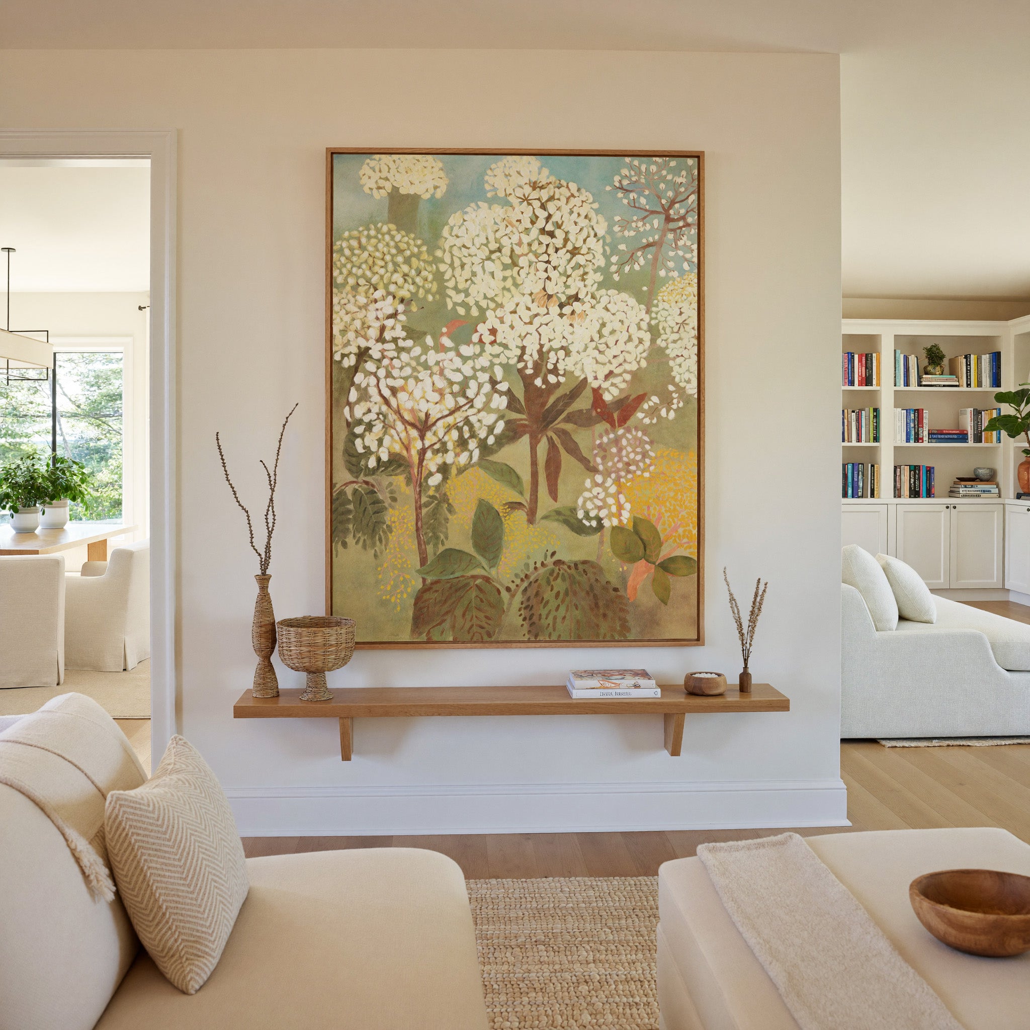 soft floral trees with cream blossoms and muted canvas wall art in an oak frame in a living room