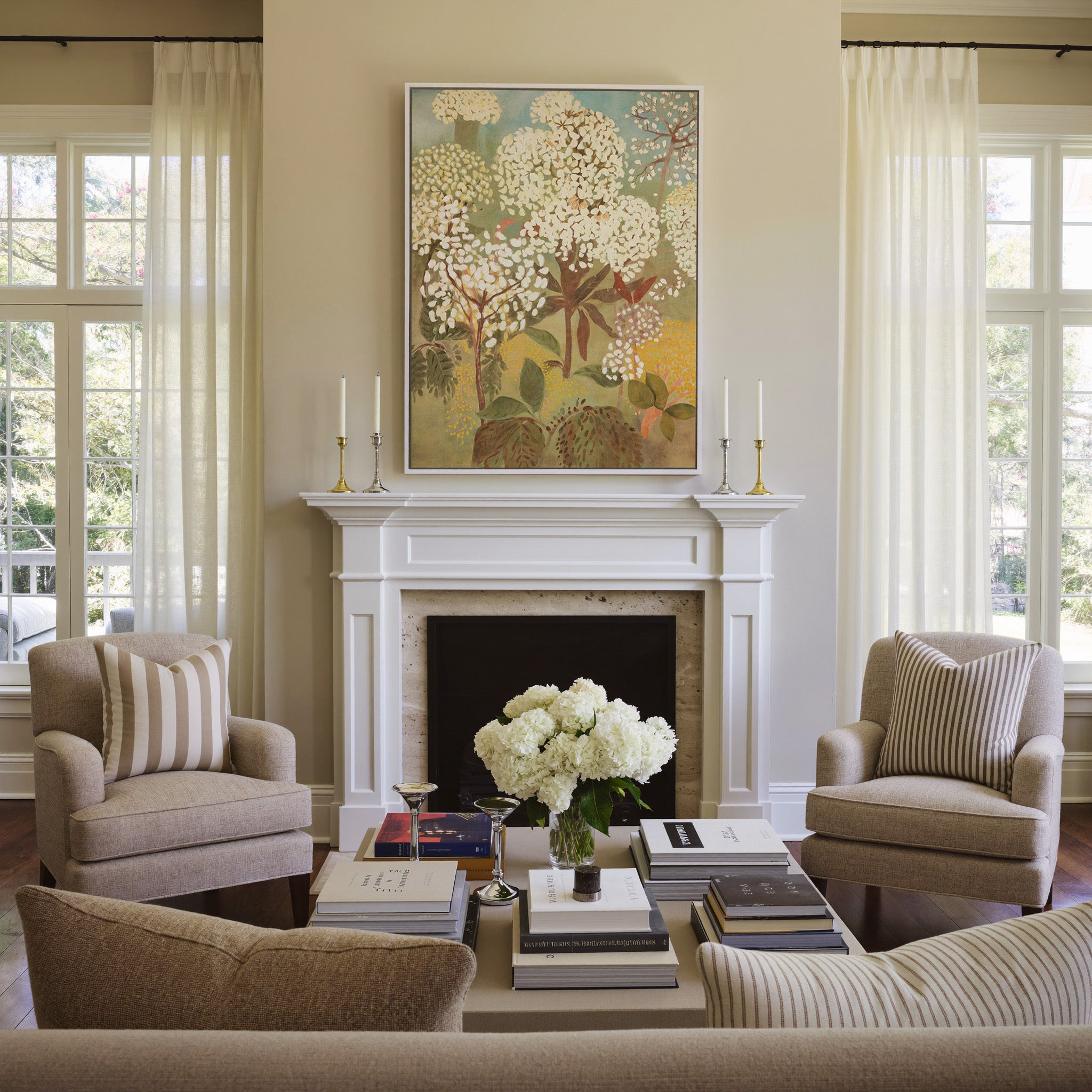 soft floral trees with cream blossoms and muted canvas wall art in a white frame above a mantel