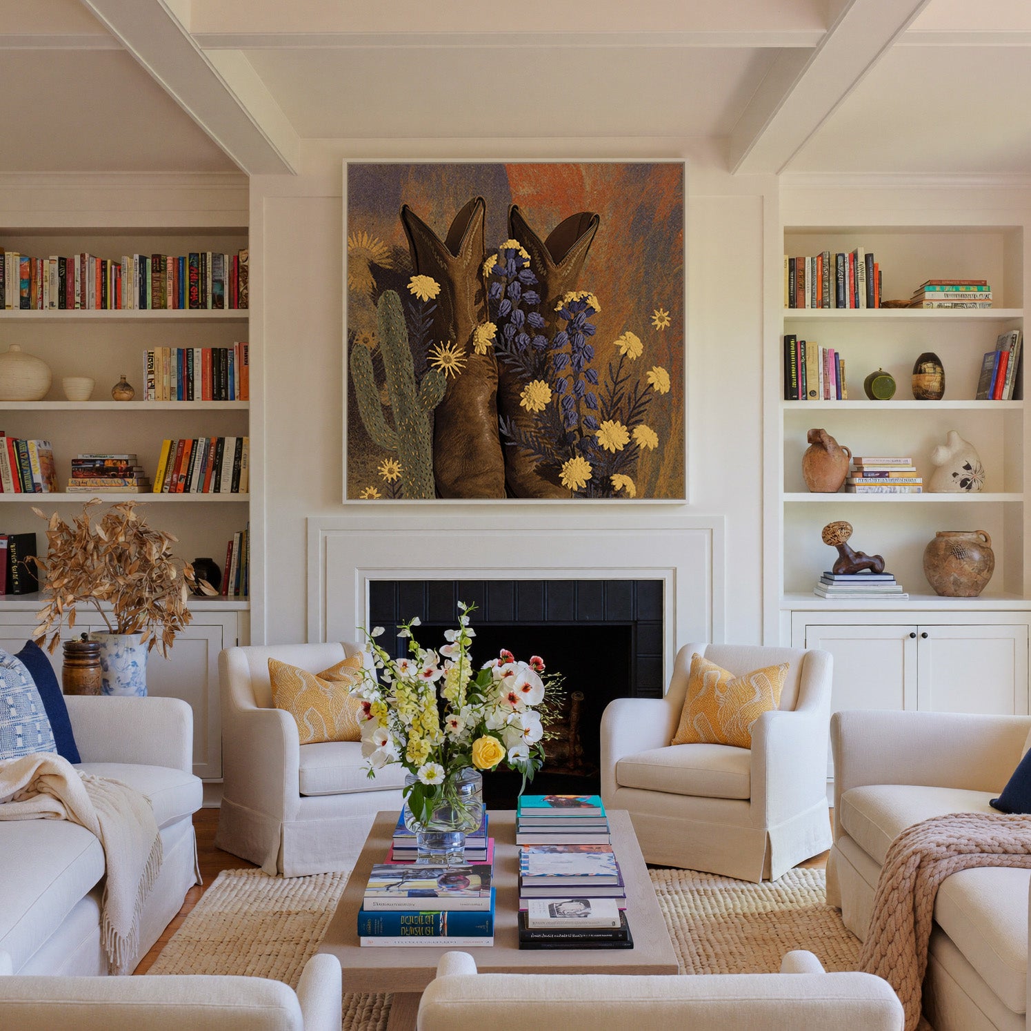 brown boots with yellow and blue wildflowers canvas wall art in a white frame above a fireplace