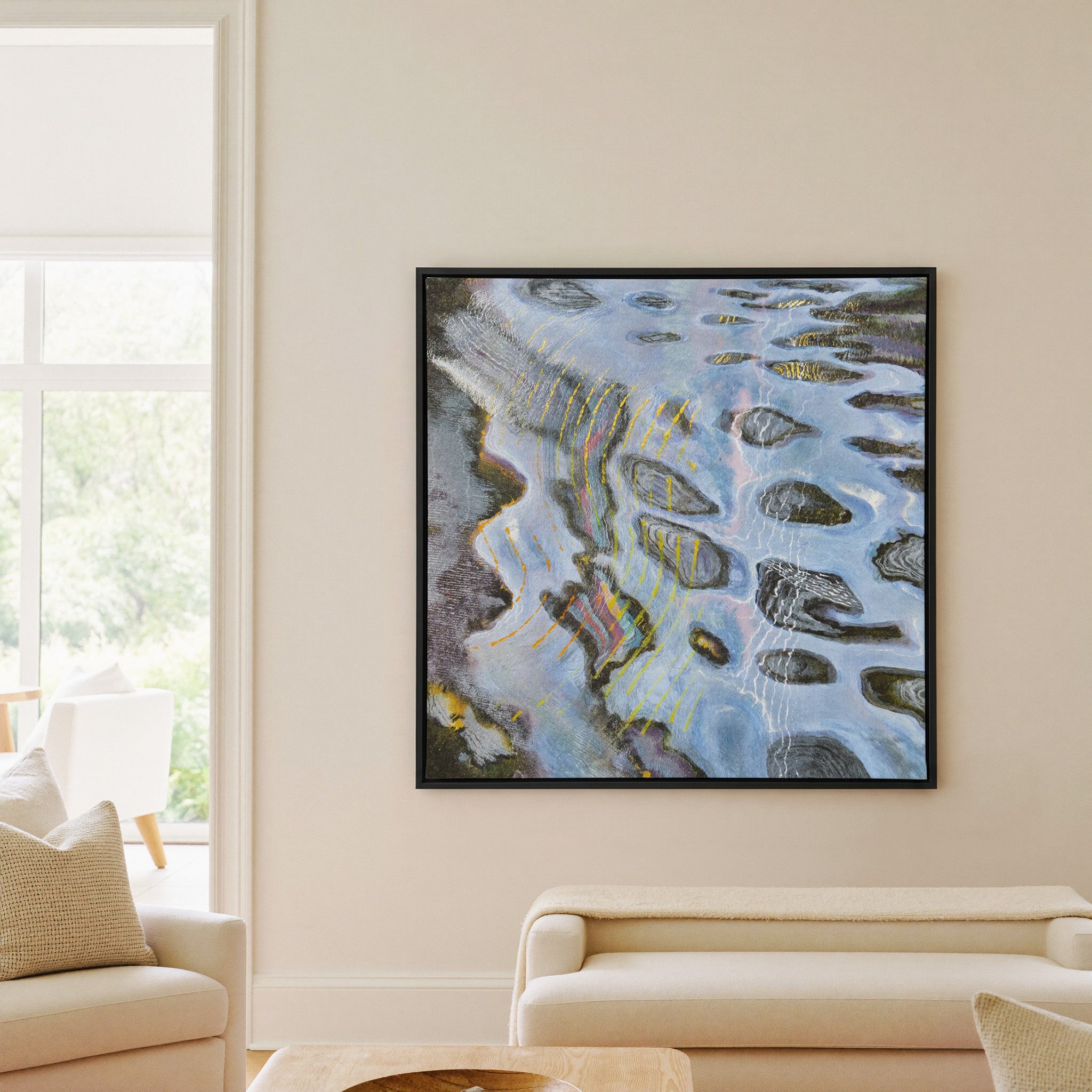 blue gray abstract with dark oval forms and canvas wall art in a black frame in a living room