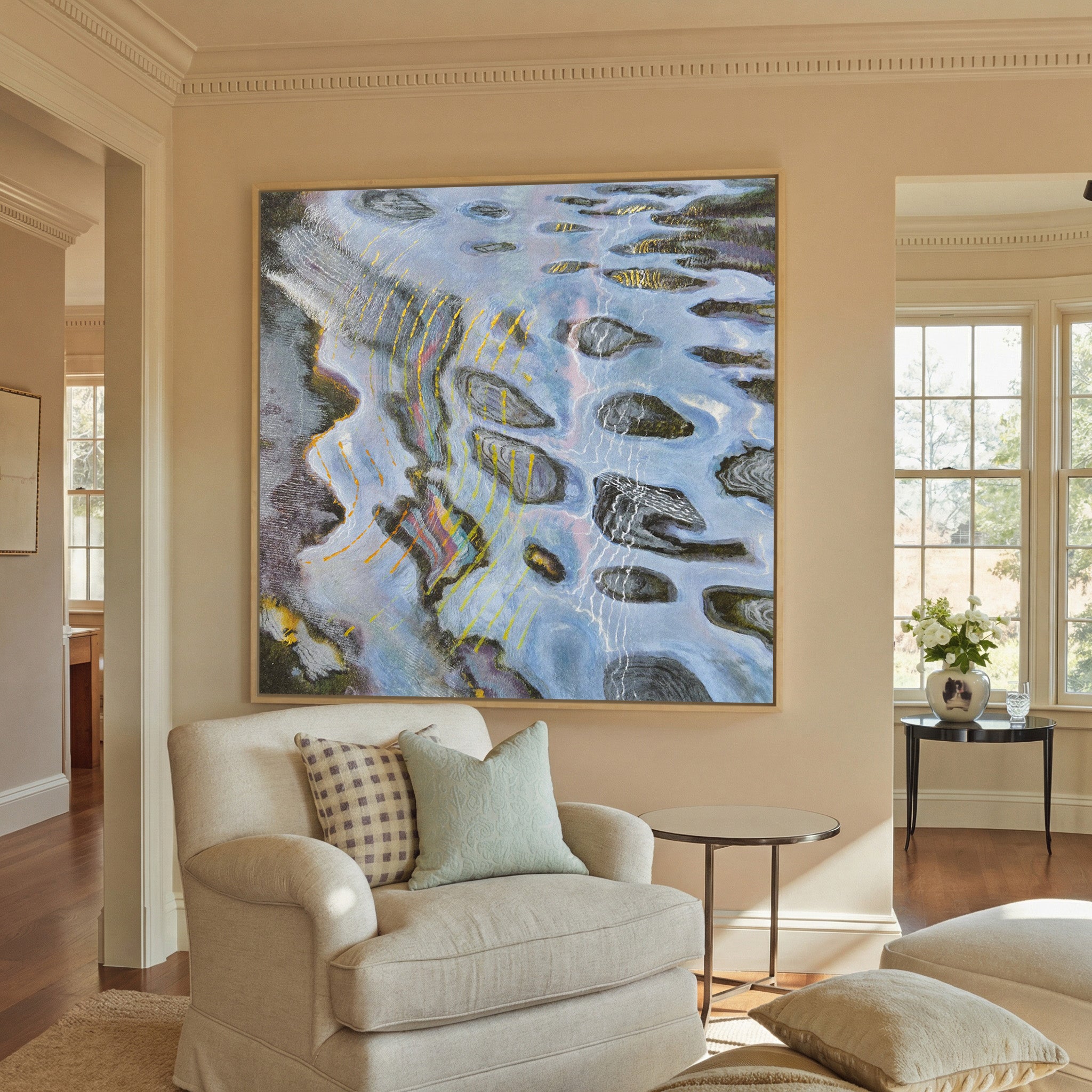 blue gray abstract with dark oval forms and canvas wall art in a natural wood frame in a styled room setting