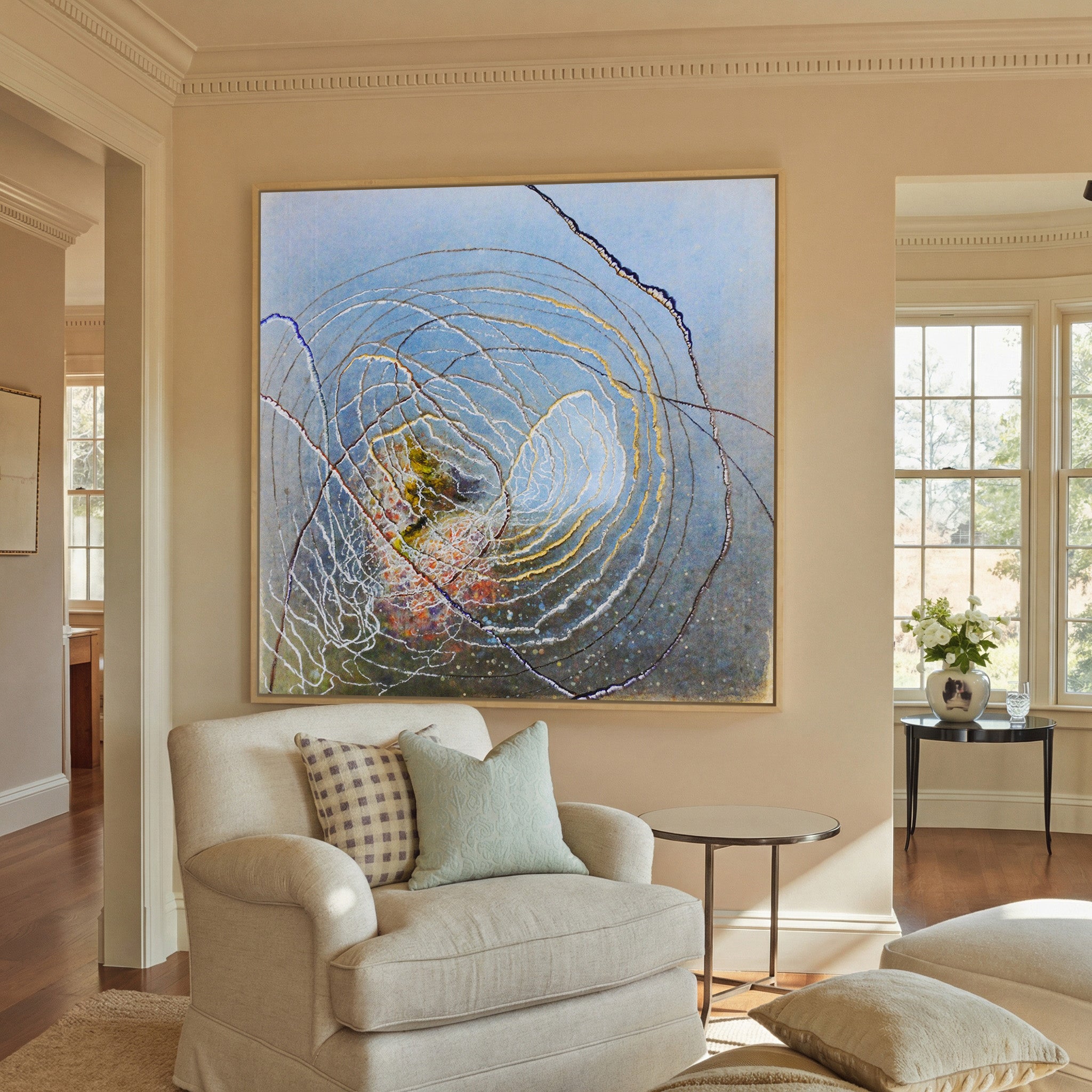 blue abstract with concentric rings and dark canvas wall art in a natural wood frame in a styled room setting