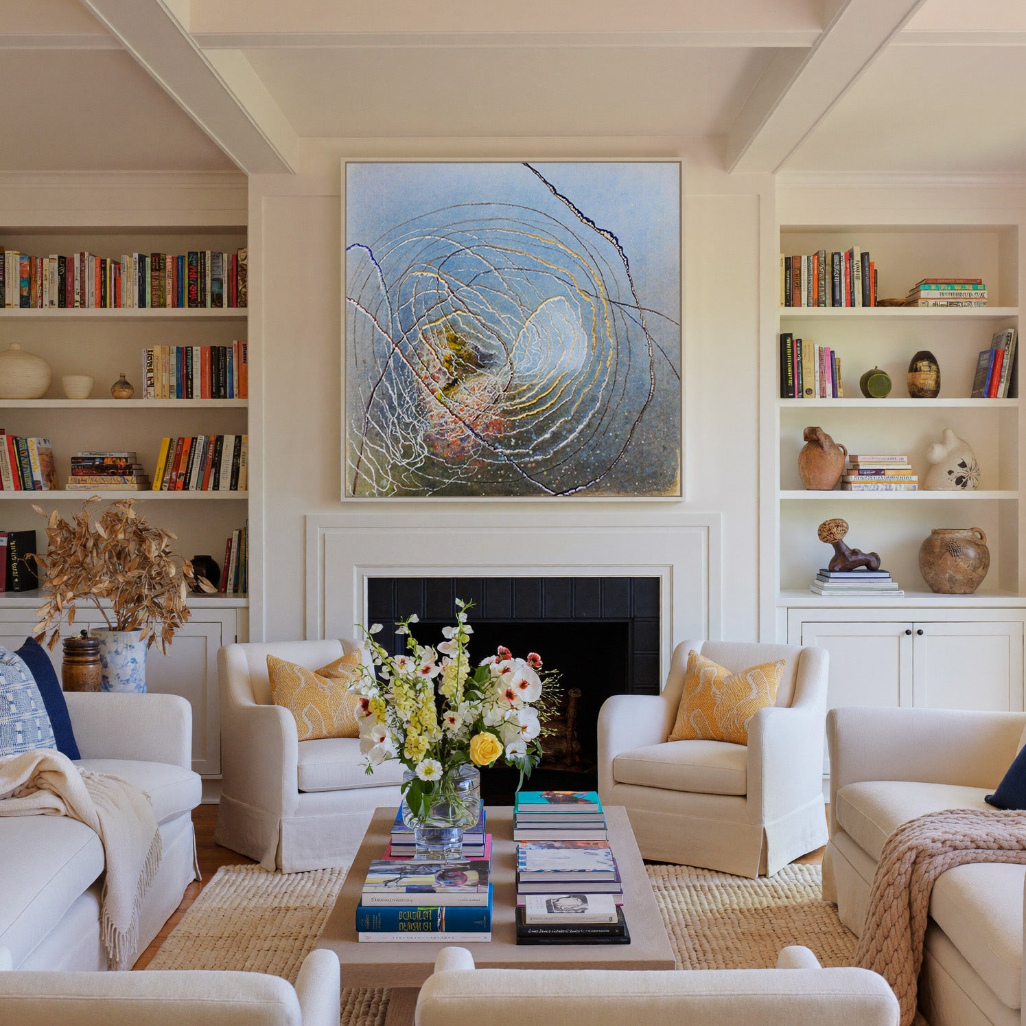 blue abstract with concentric rings and dark canvas wall art in a white frame above a fireplace