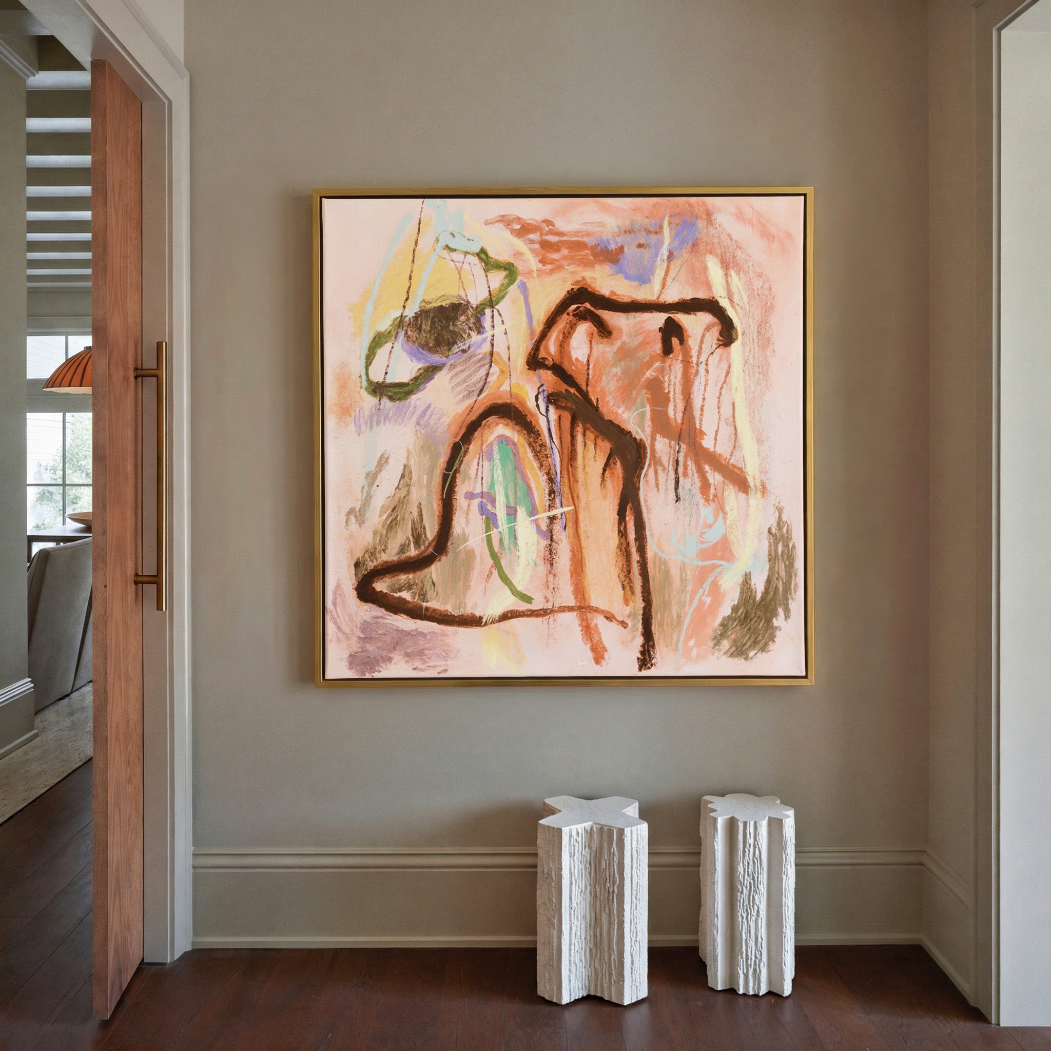 warm peach abstract with dark looping lines and canvas wall art in a gold frame in a styled room setting