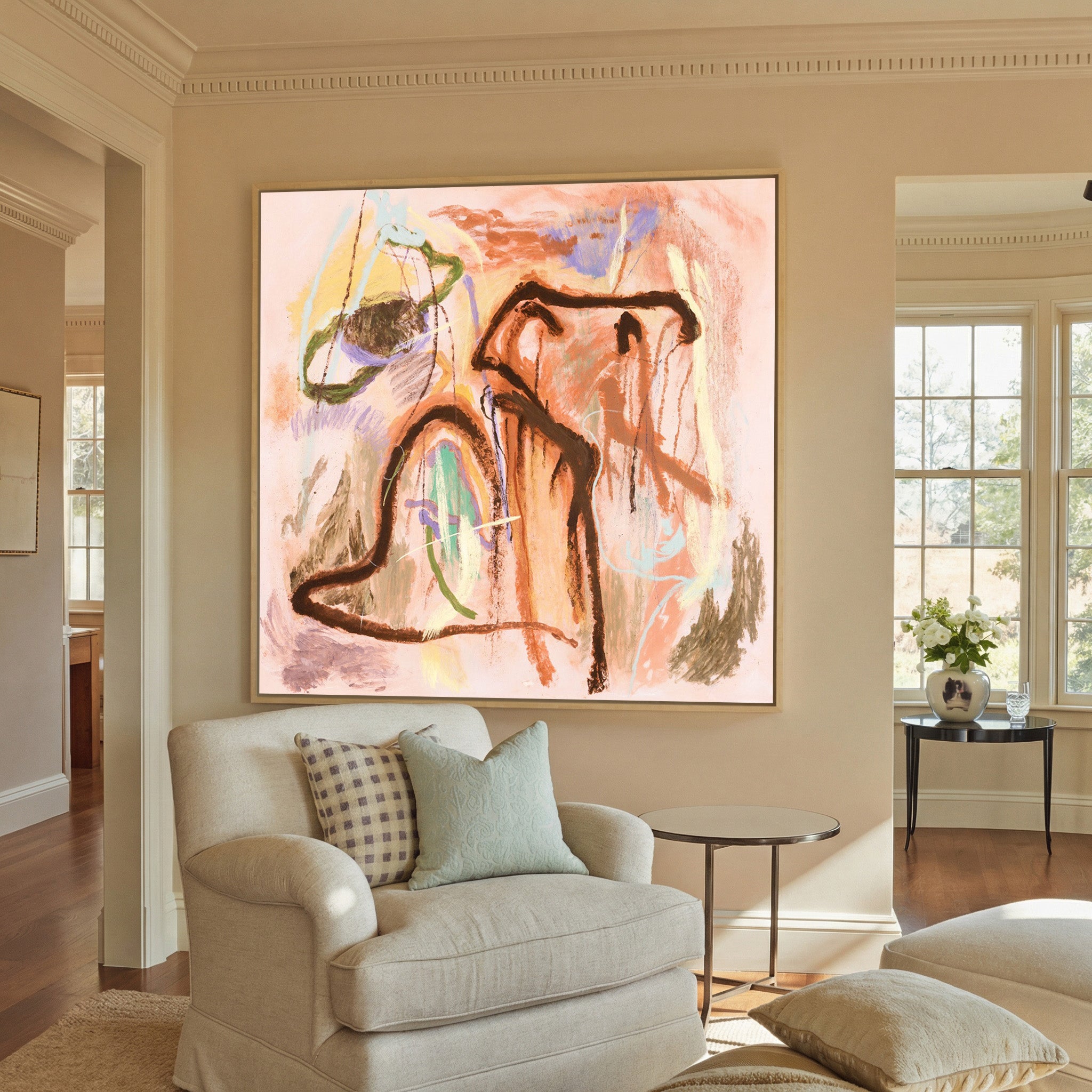 warm peach abstract with dark canvas wall art in a natural wood frame in a styled room setting