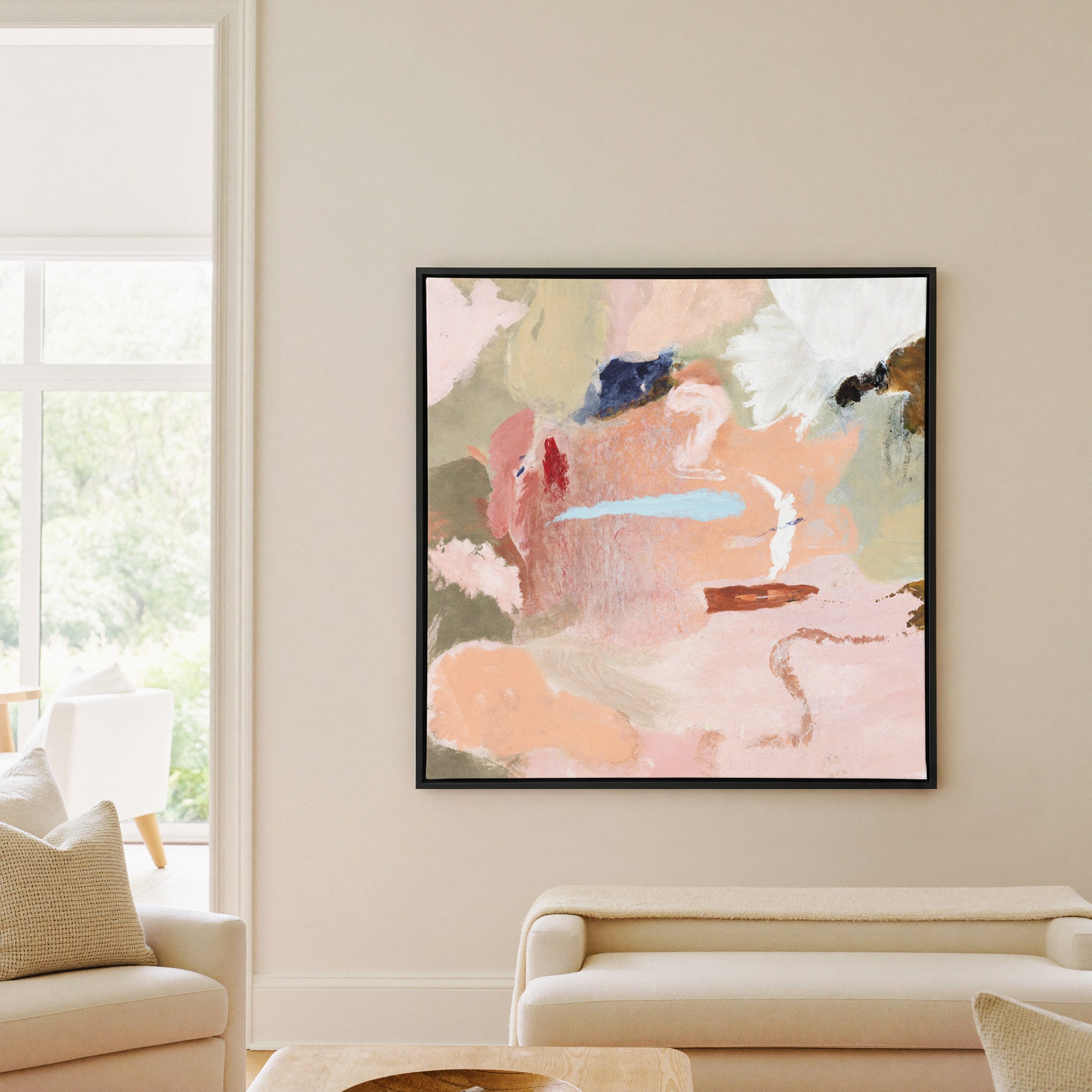 soft peach and blush abstract with cream, sage, canvas wall art in a black frame in a living room