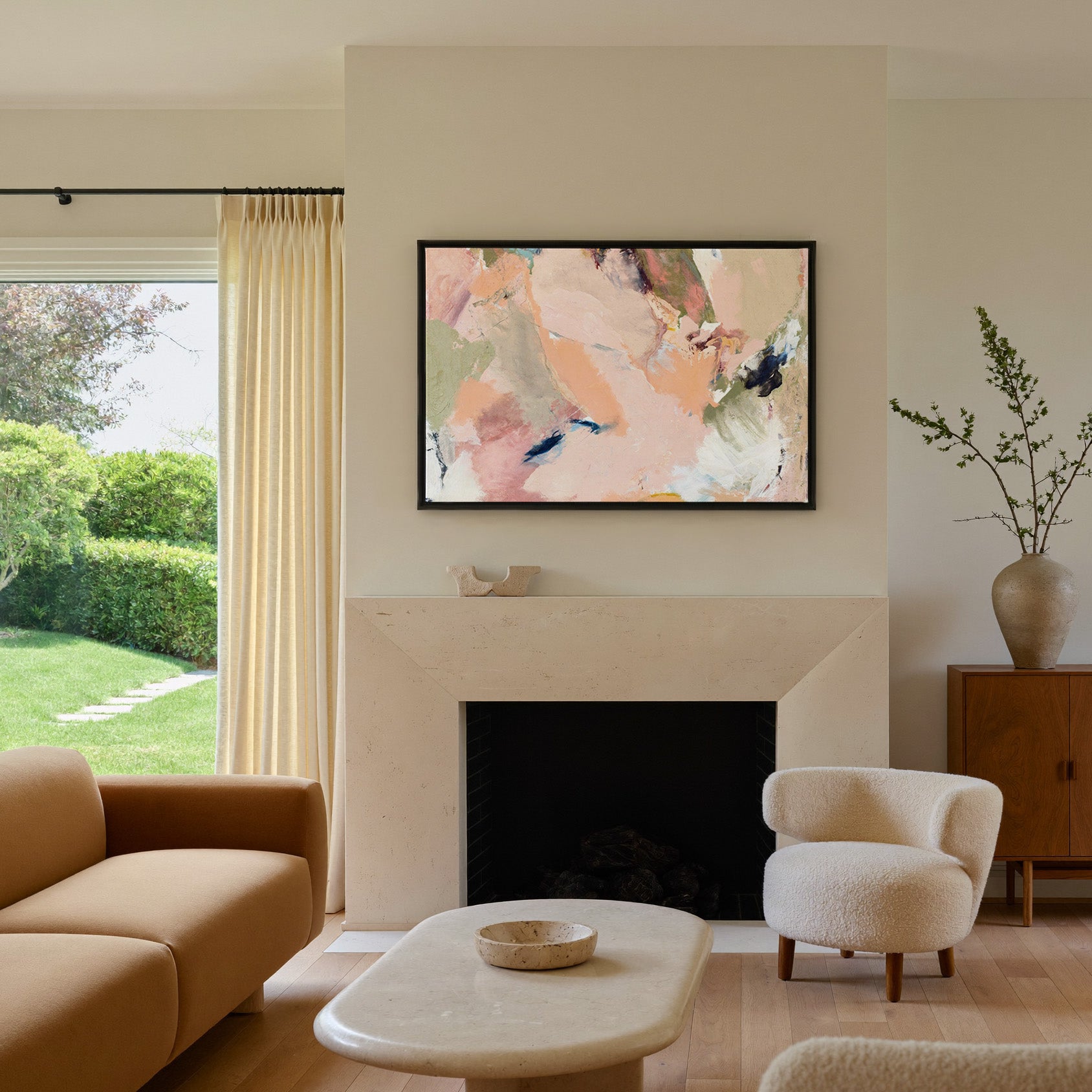 soft blush, peach, sage, and navy abstract canvas wall art in a black frame above a mantel