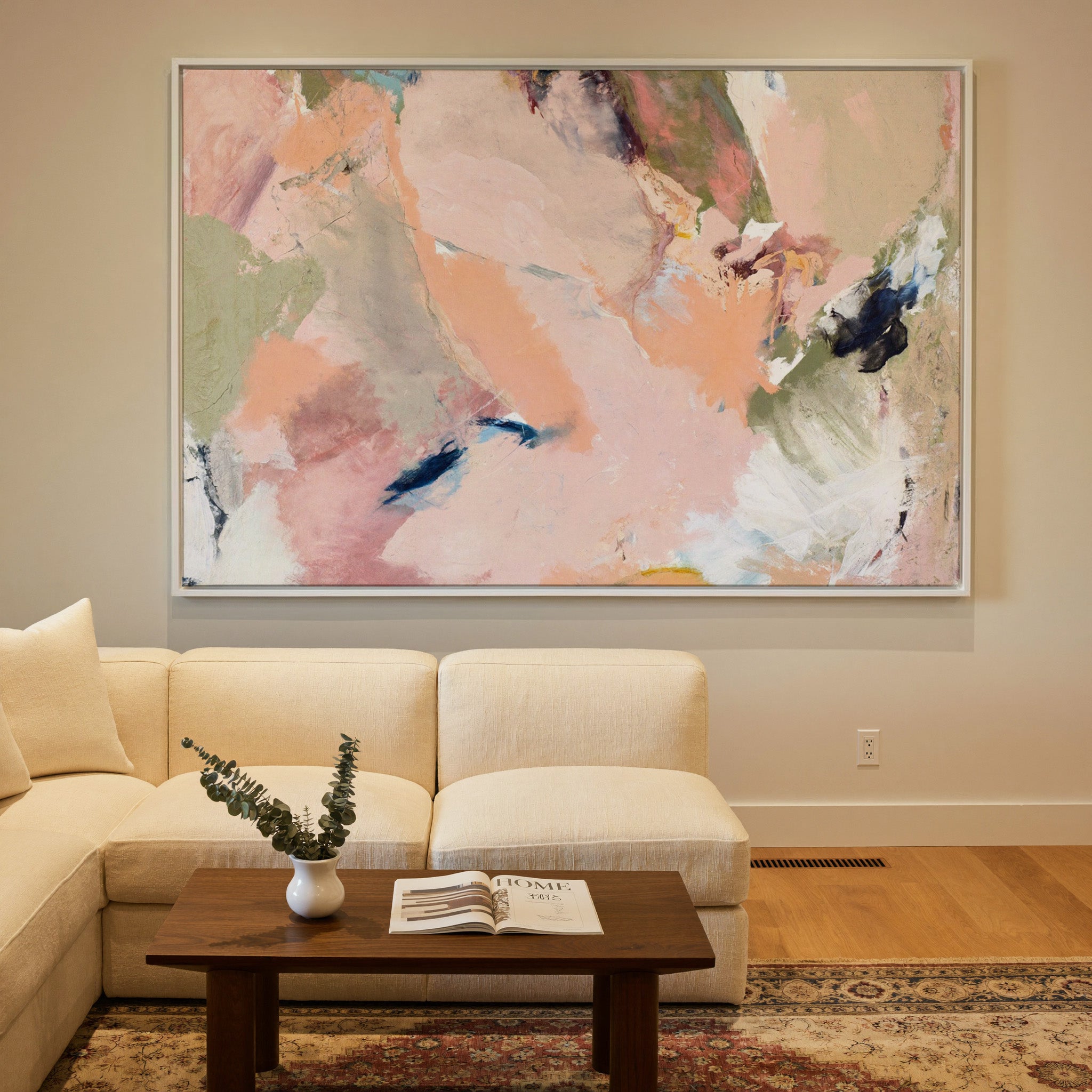 soft blush, peach, sage, and navy abstract canvas wall art in a white frame in a styled room setting