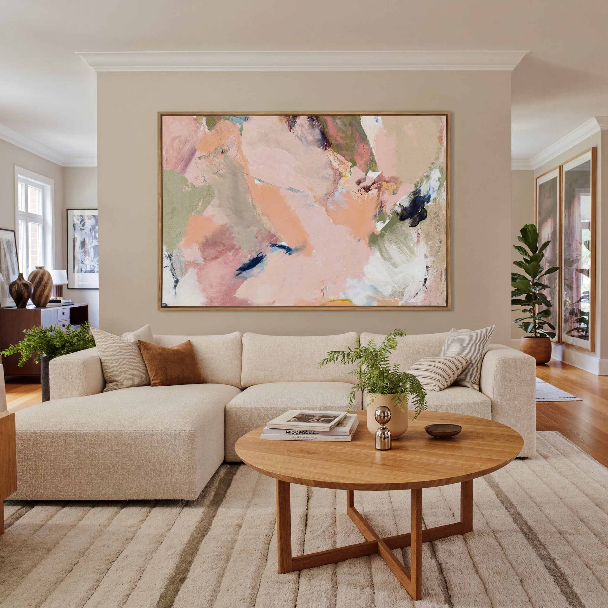 soft blush, peach, sage, and navy abstract canvas wall art in an oak frame in a living room