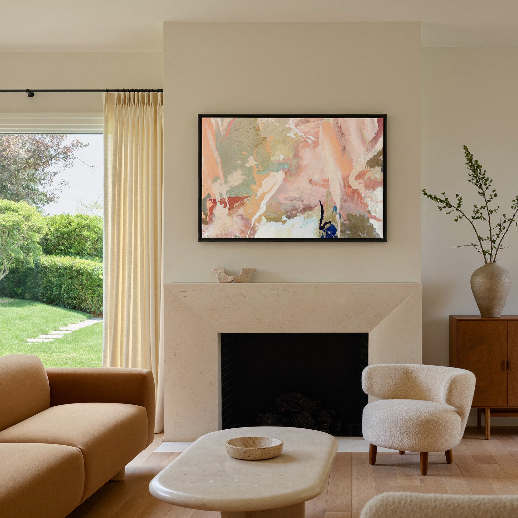 soft peach and sage abstract canvas wall art in a black frame above a mantel