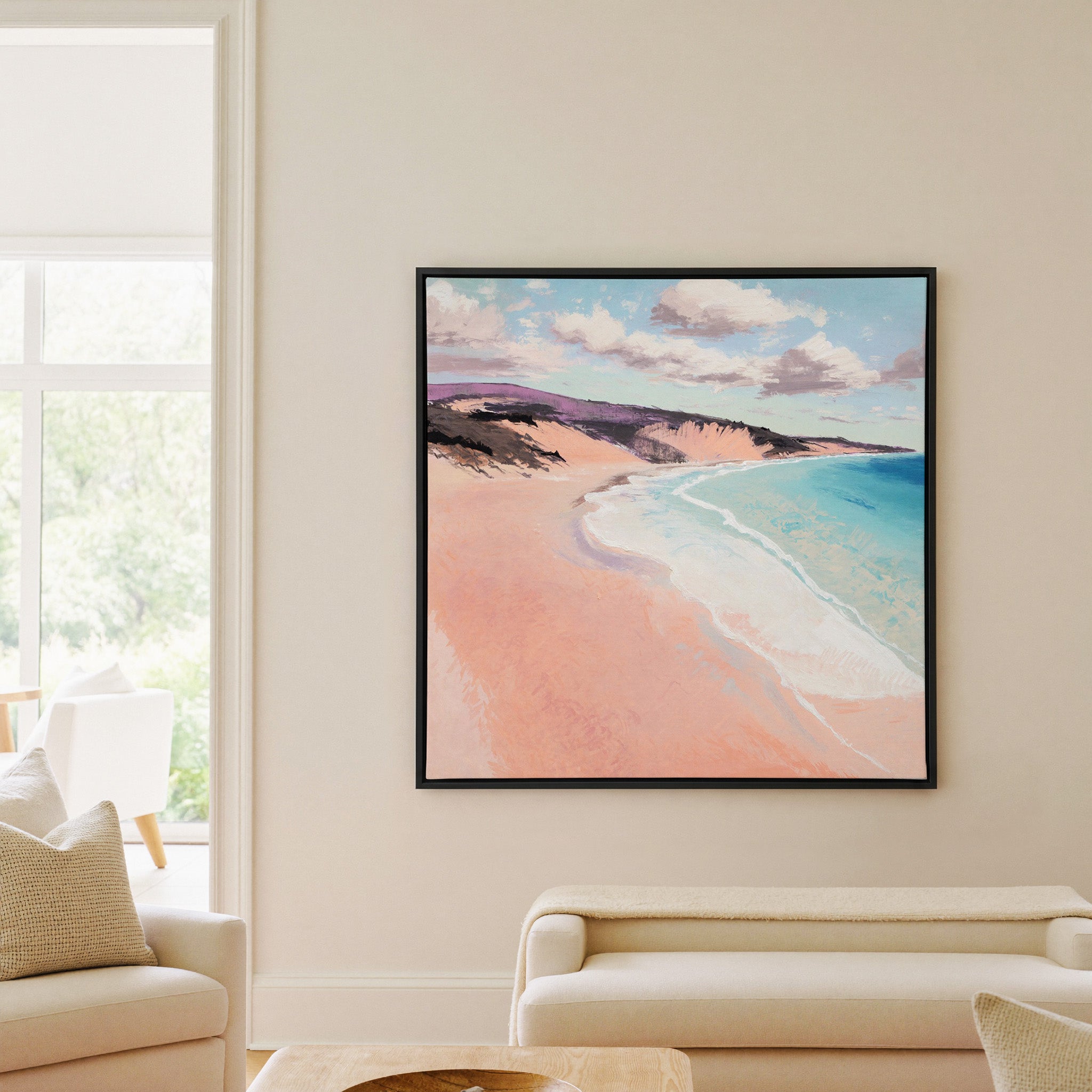 soft peach beach with turquoise water and canvas wall art in a black frame in a living room
