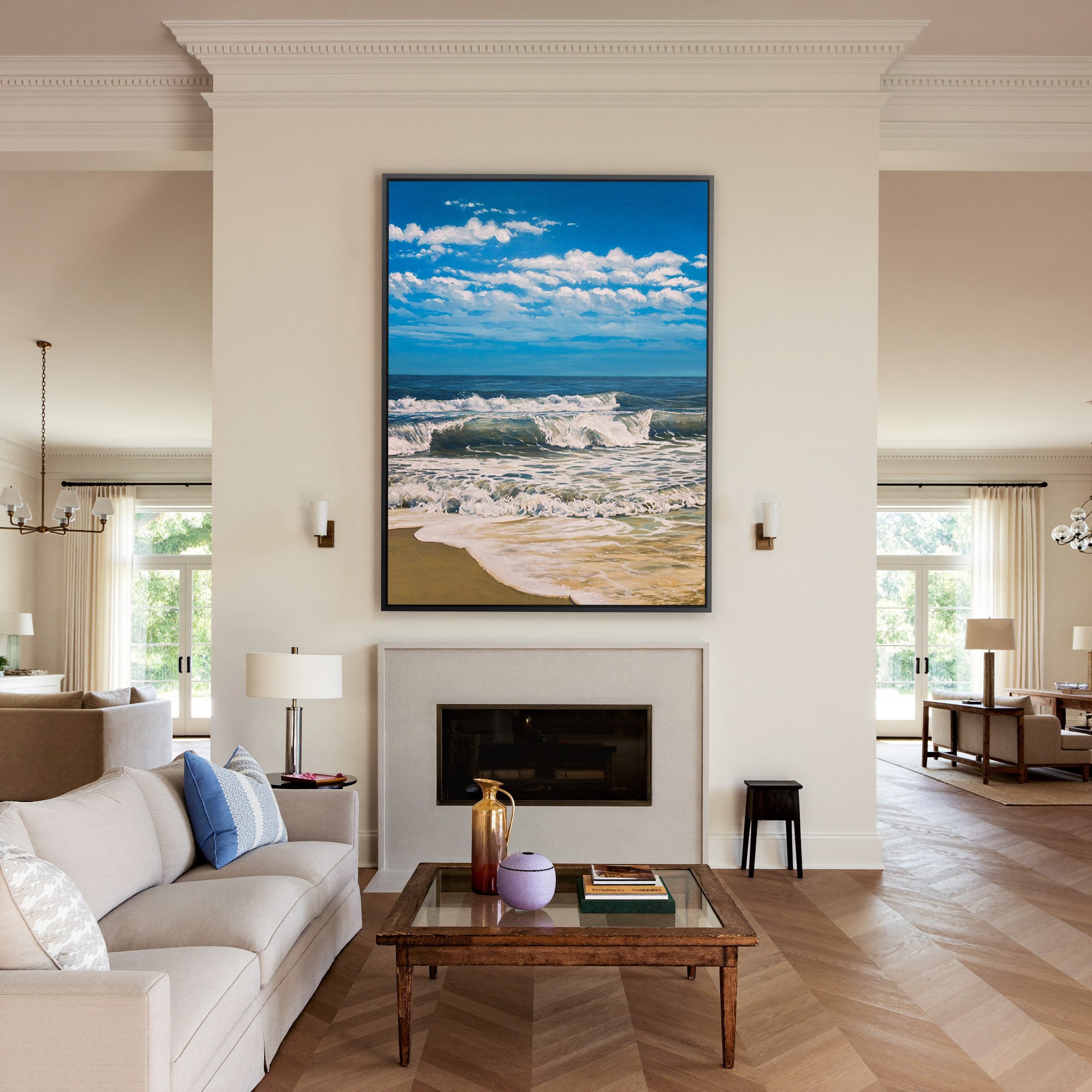 bright blue seascape with foamy surf and a wide canvas wall art in a black frame above a mantel