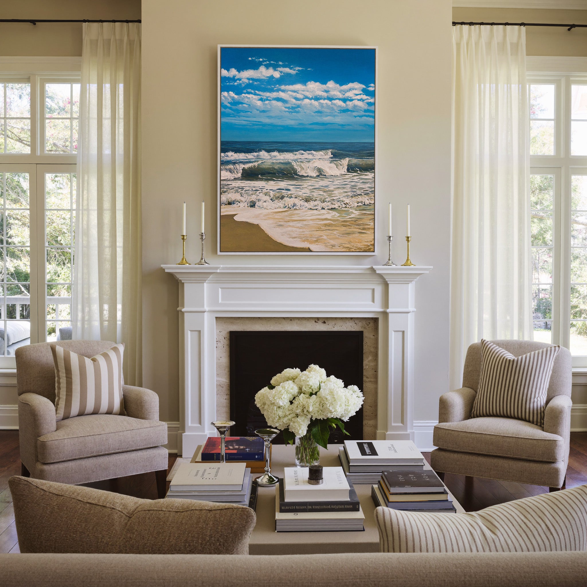 bright blue seascape with foamy surf and a wide canvas wall art in a white frame above a mantel