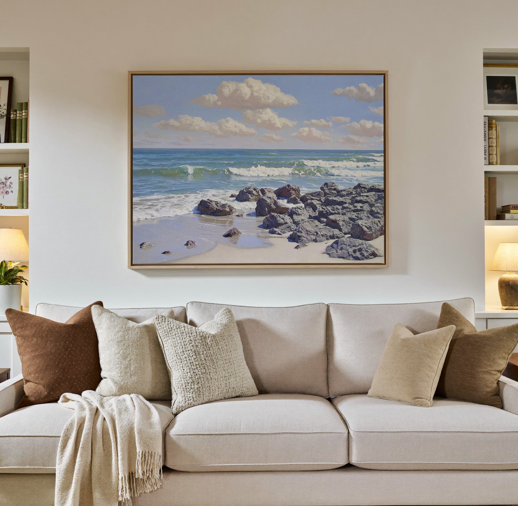 rocky shore with rolling surf and soft cloud canvas wall art in a natural wood frame in a styled room setting