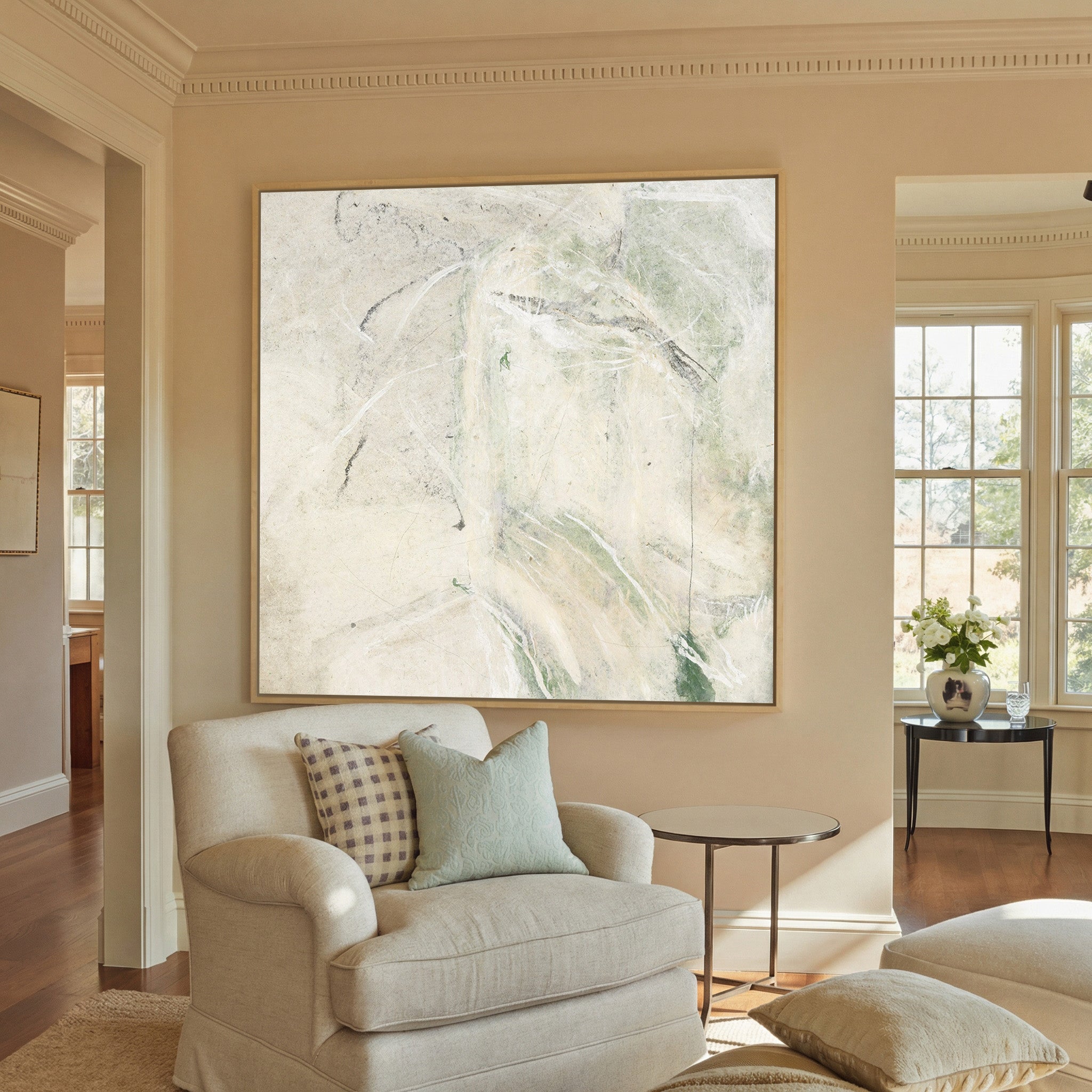 soft cream abstract with pale canvas wall art in a natural wood frame in a styled room setting