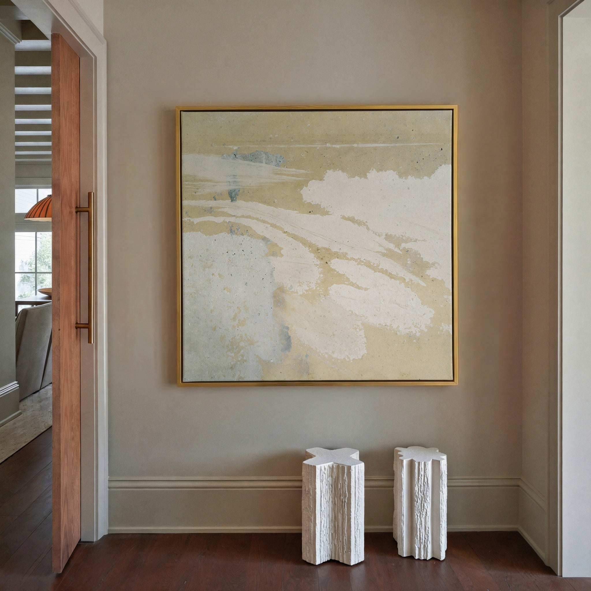 cream and sand abstract with pale blue streaks canvas wall art in a gold frame in a styled room setting
