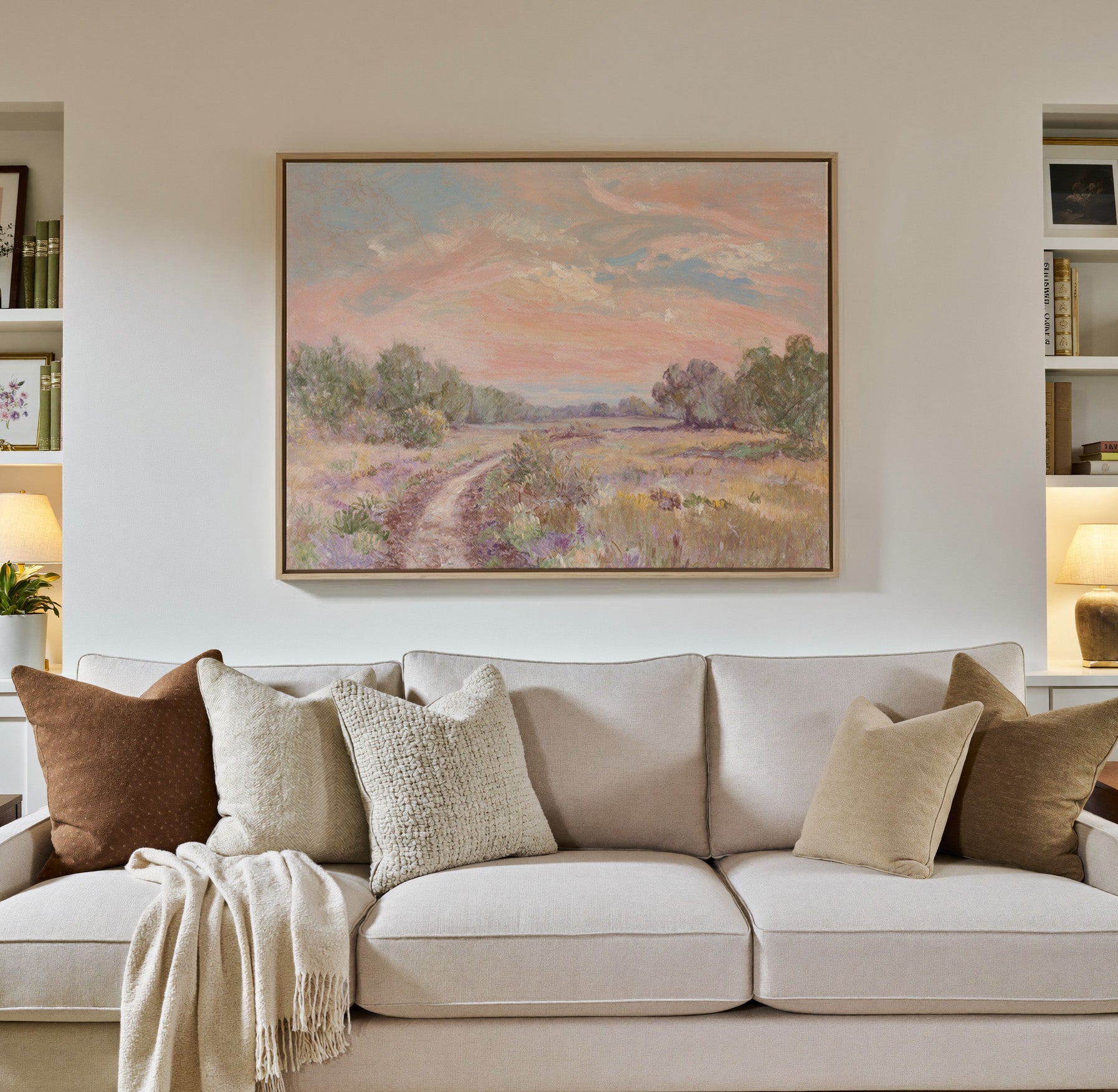 soft pink sky over a winding meadow path canvas wall art in a natural wood frame in a styled room setting
